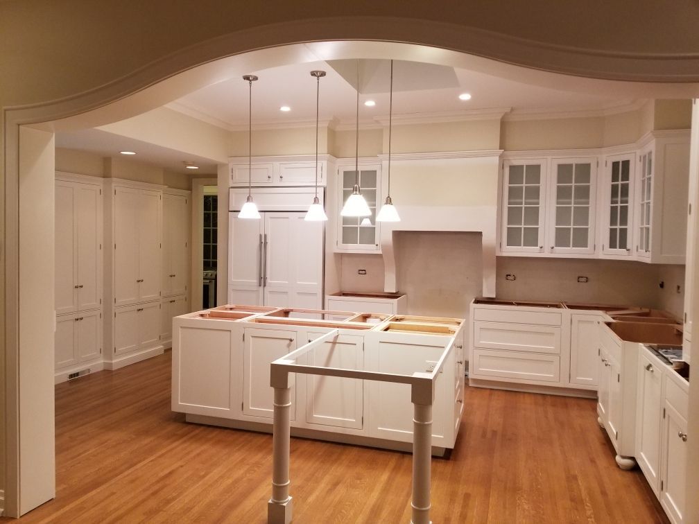 A kitchen with white cabinets and hardwood floors