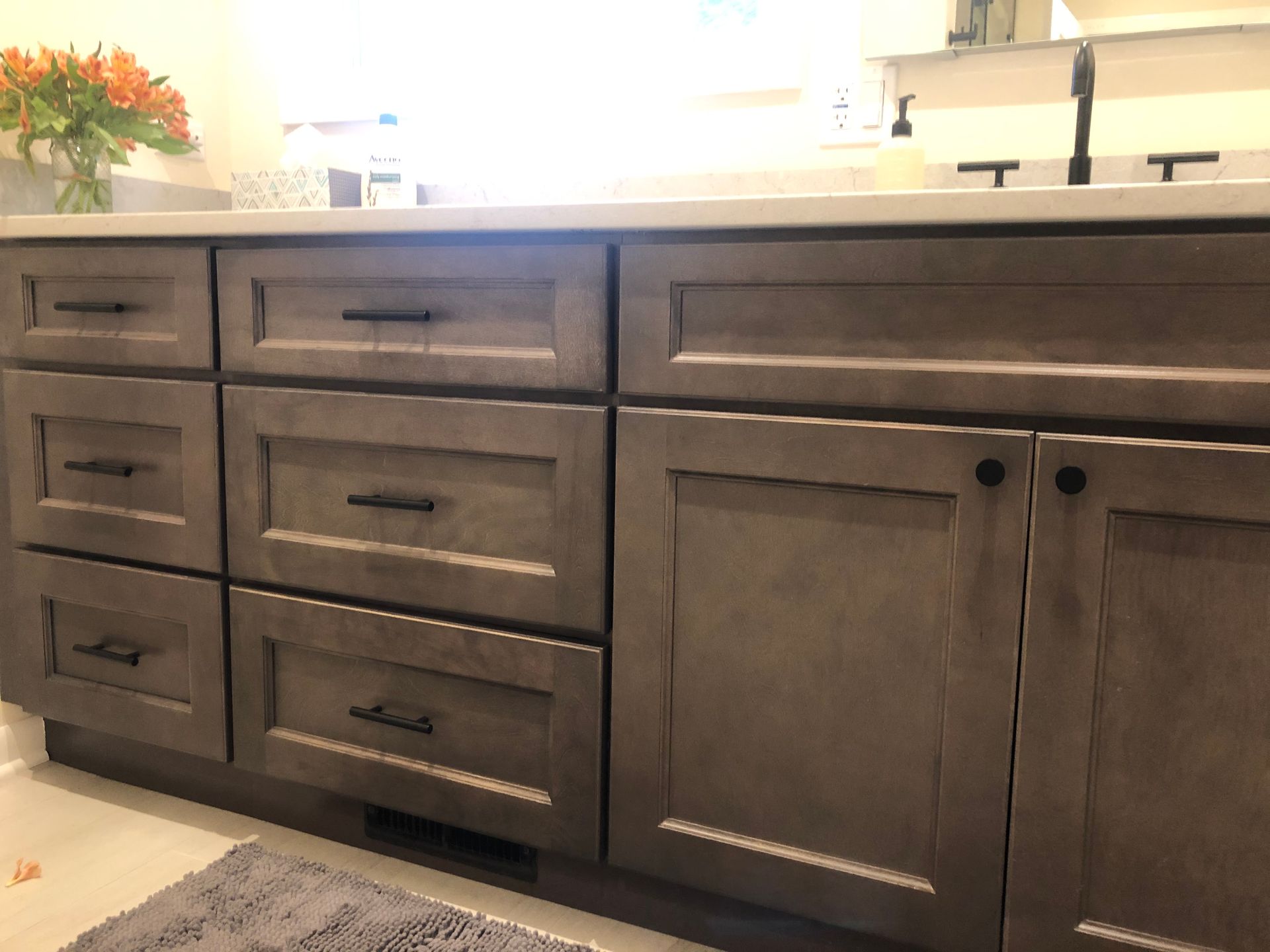 A bathroom with gray cabinets and a sink