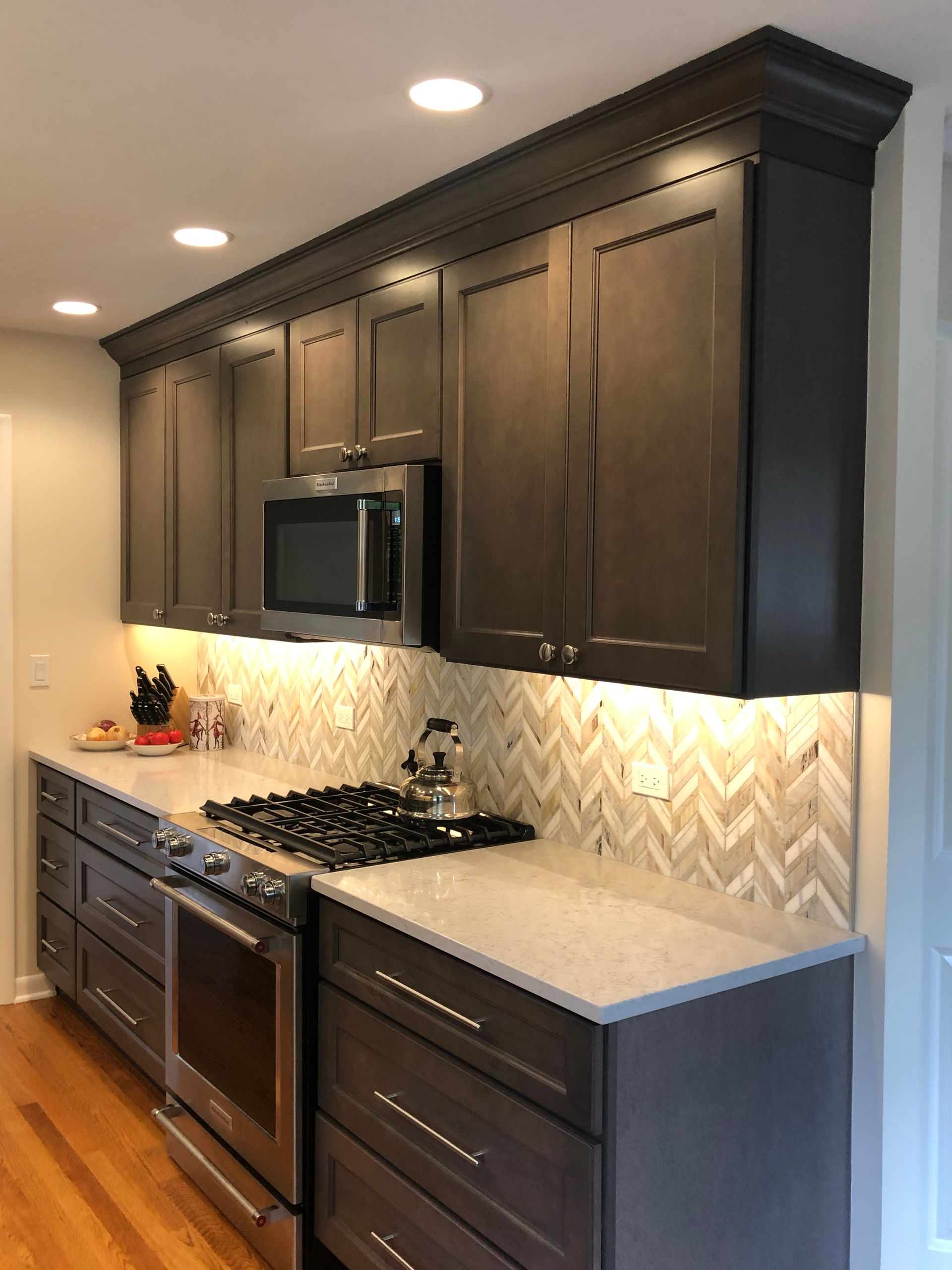 A kitchen with stainless steel appliances and gray cabinets