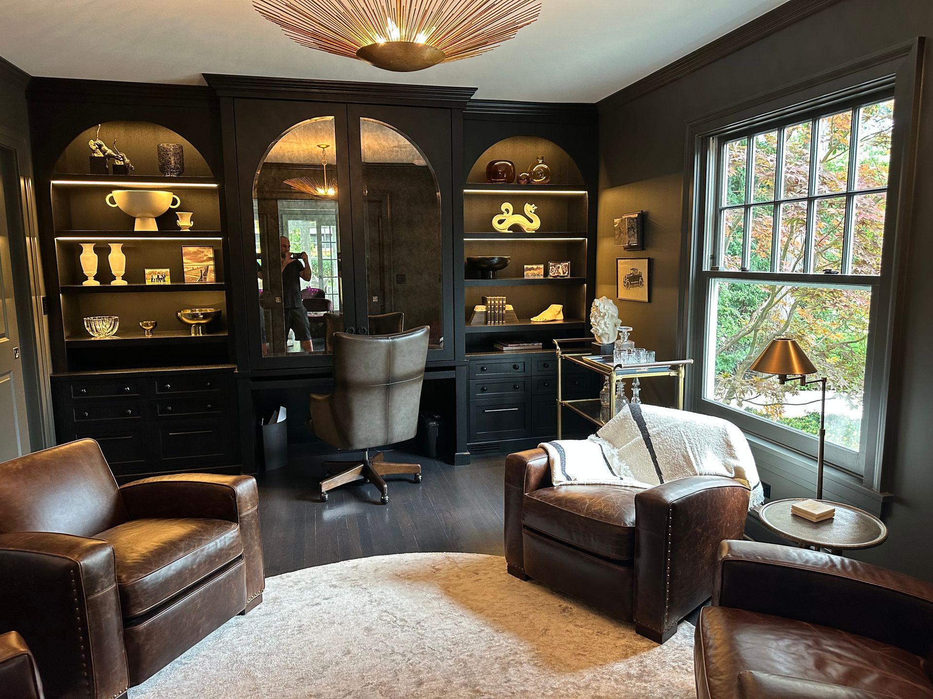 A living room with two leather chairs and a desk