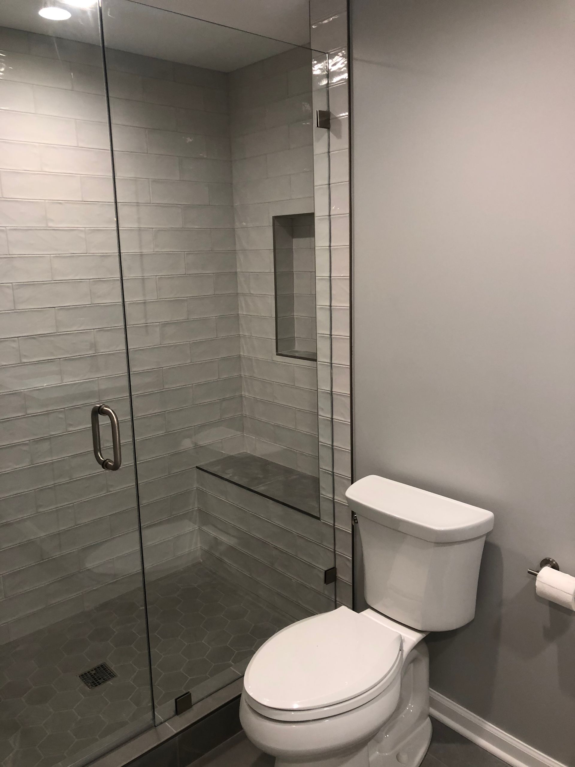 A bathroom with a toilet and a shower with a glass door.