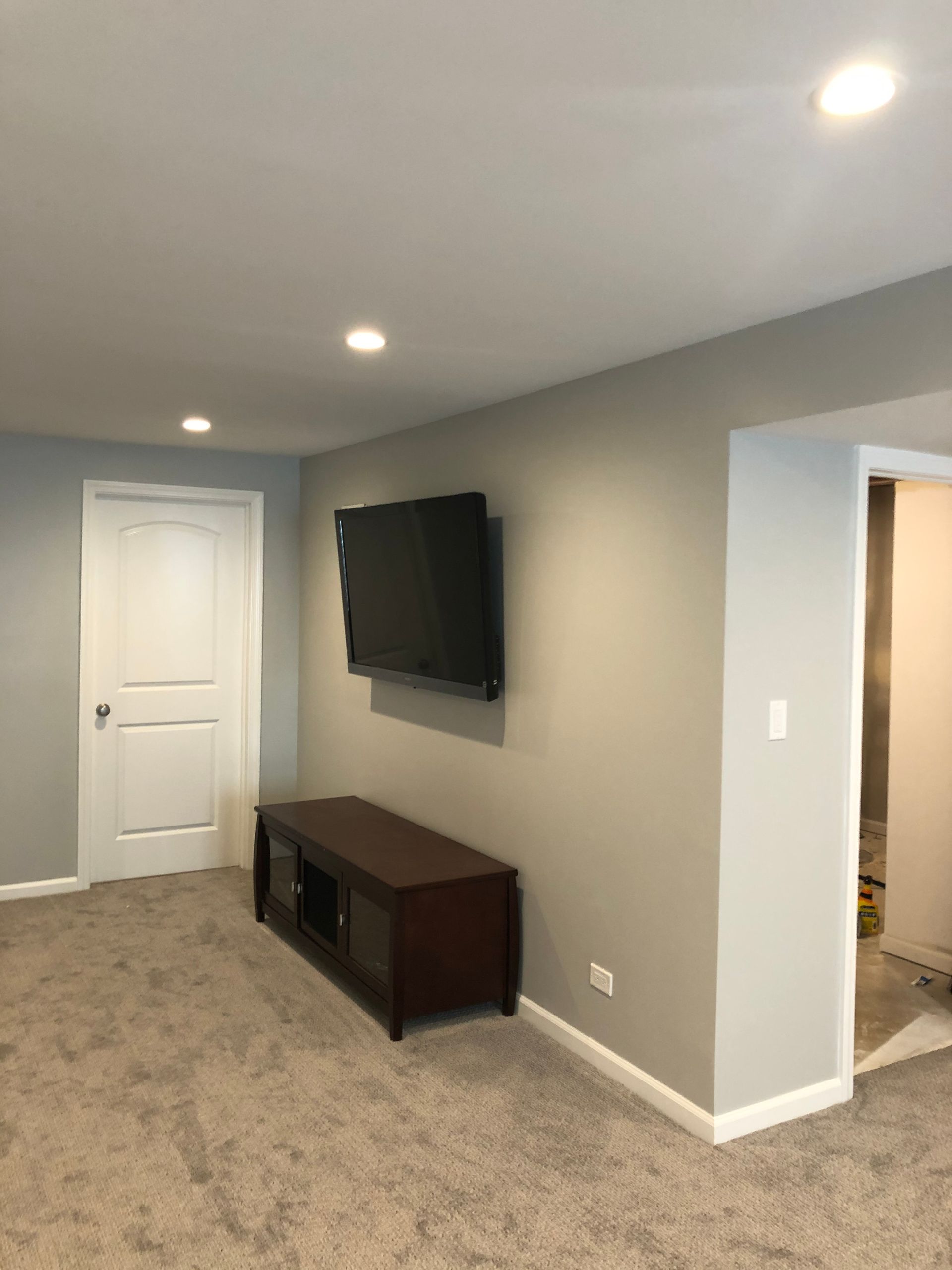 A living room with a flat screen tv on the wall.