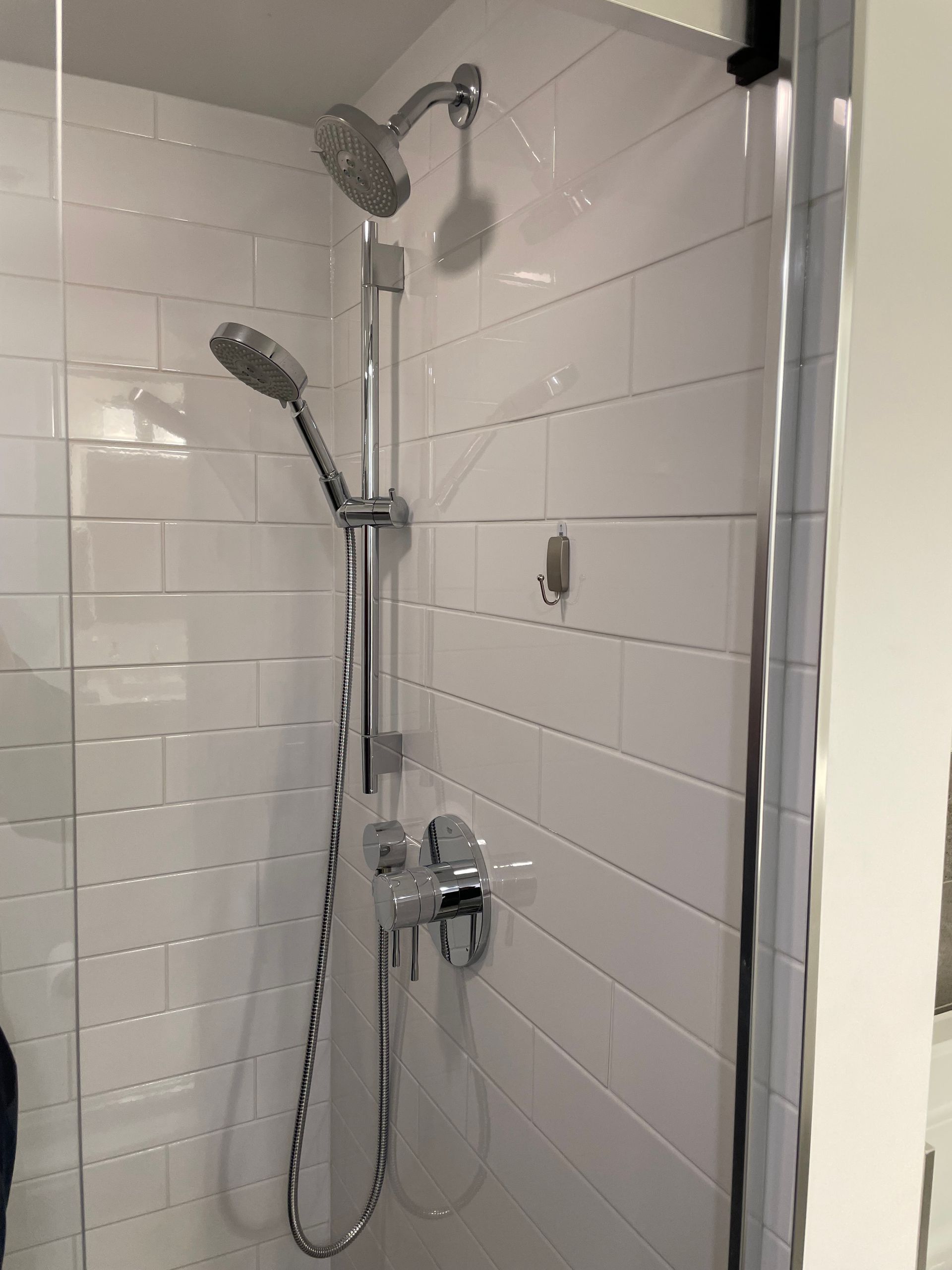 A shower with a shower head and a shower head in a bathroom.