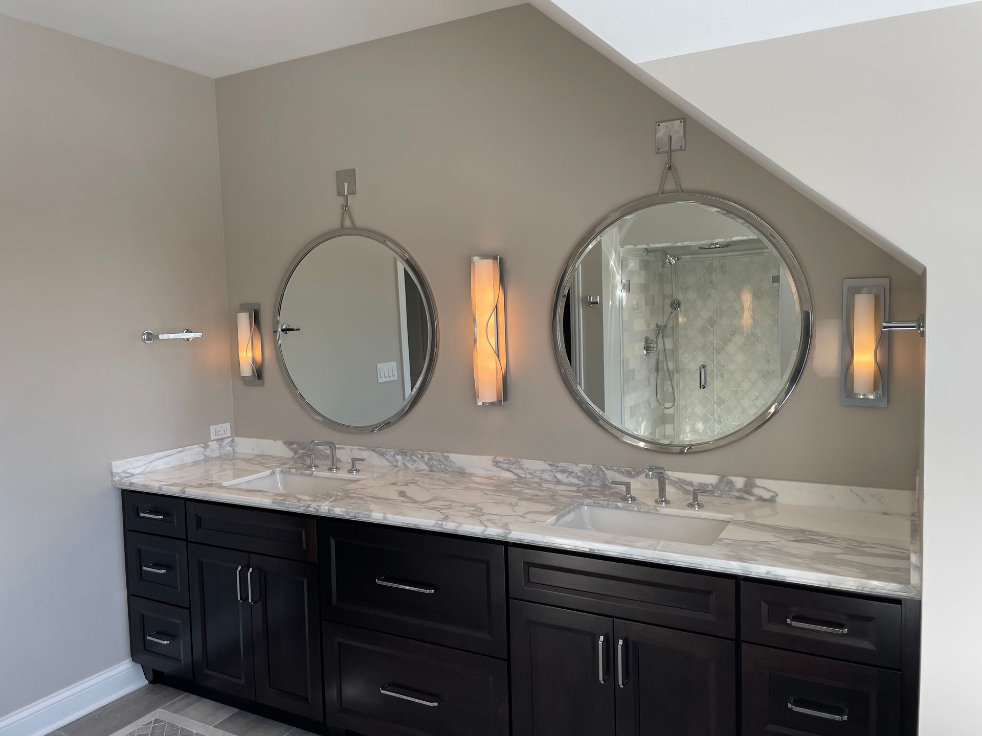 A bathroom with two sinks and two mirrors on the wall.