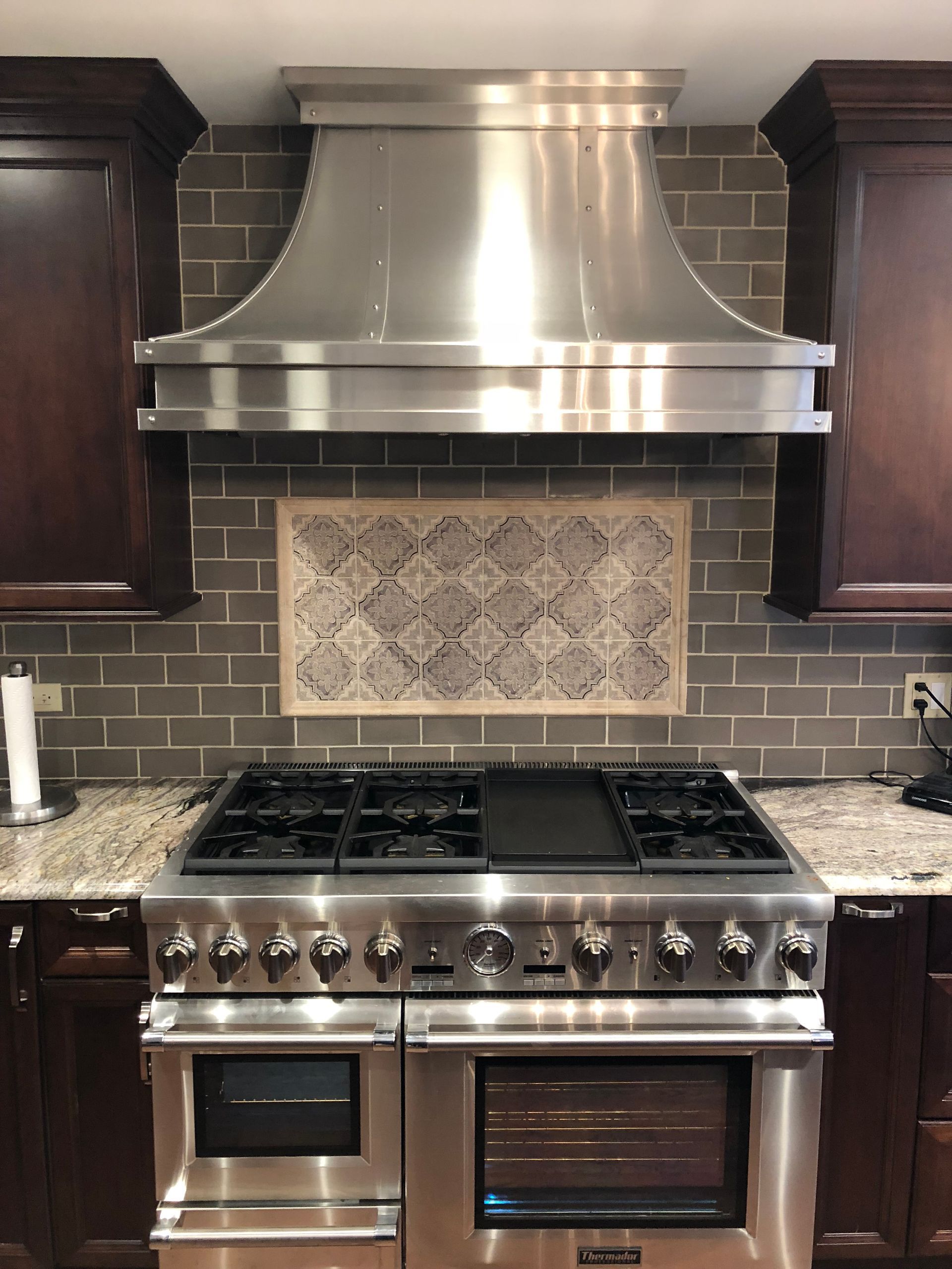 A kitchen with a stainless steel stove top oven