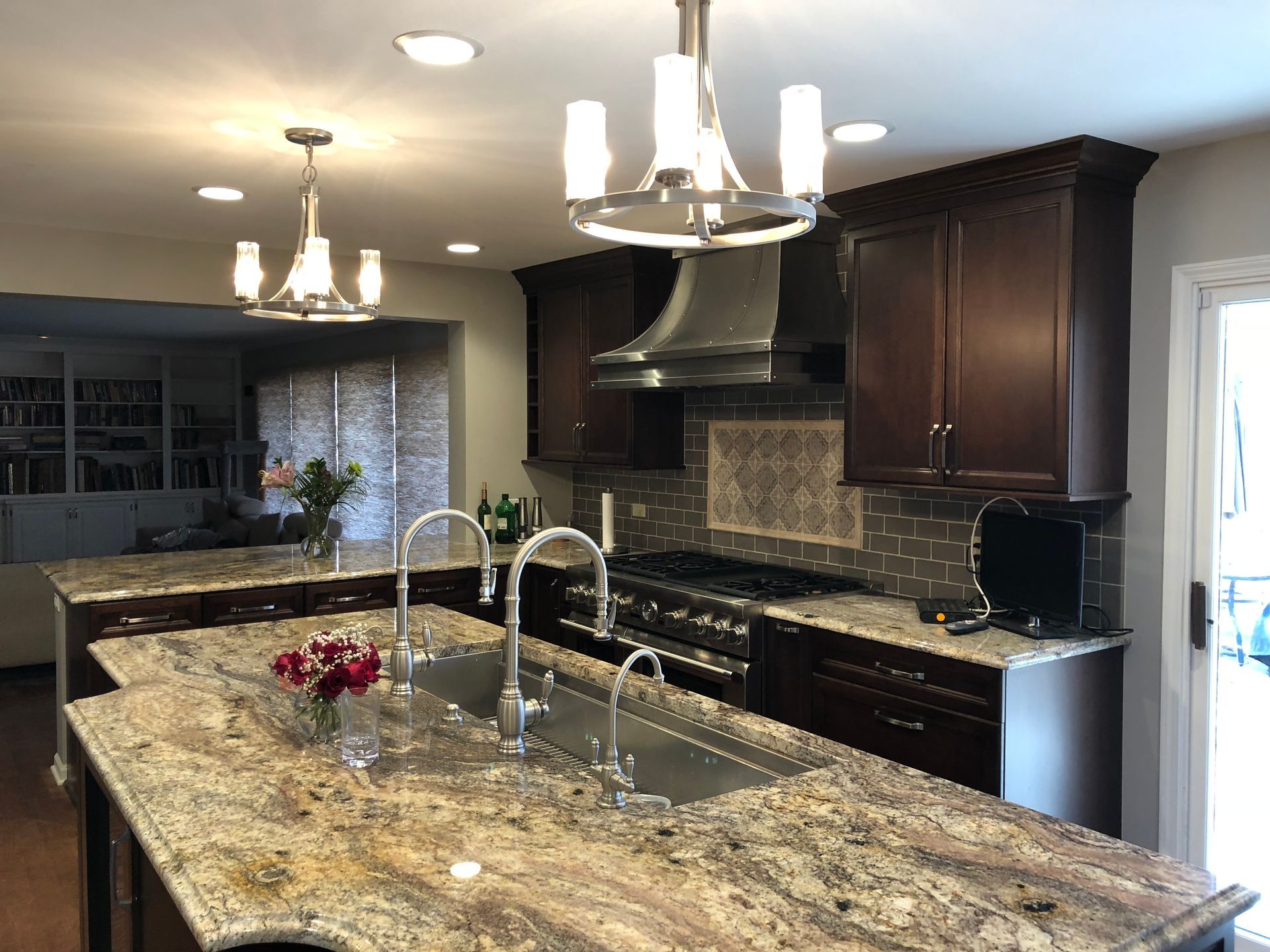 A kitchen with granite counter tops , stainless steel appliances , and a large island.