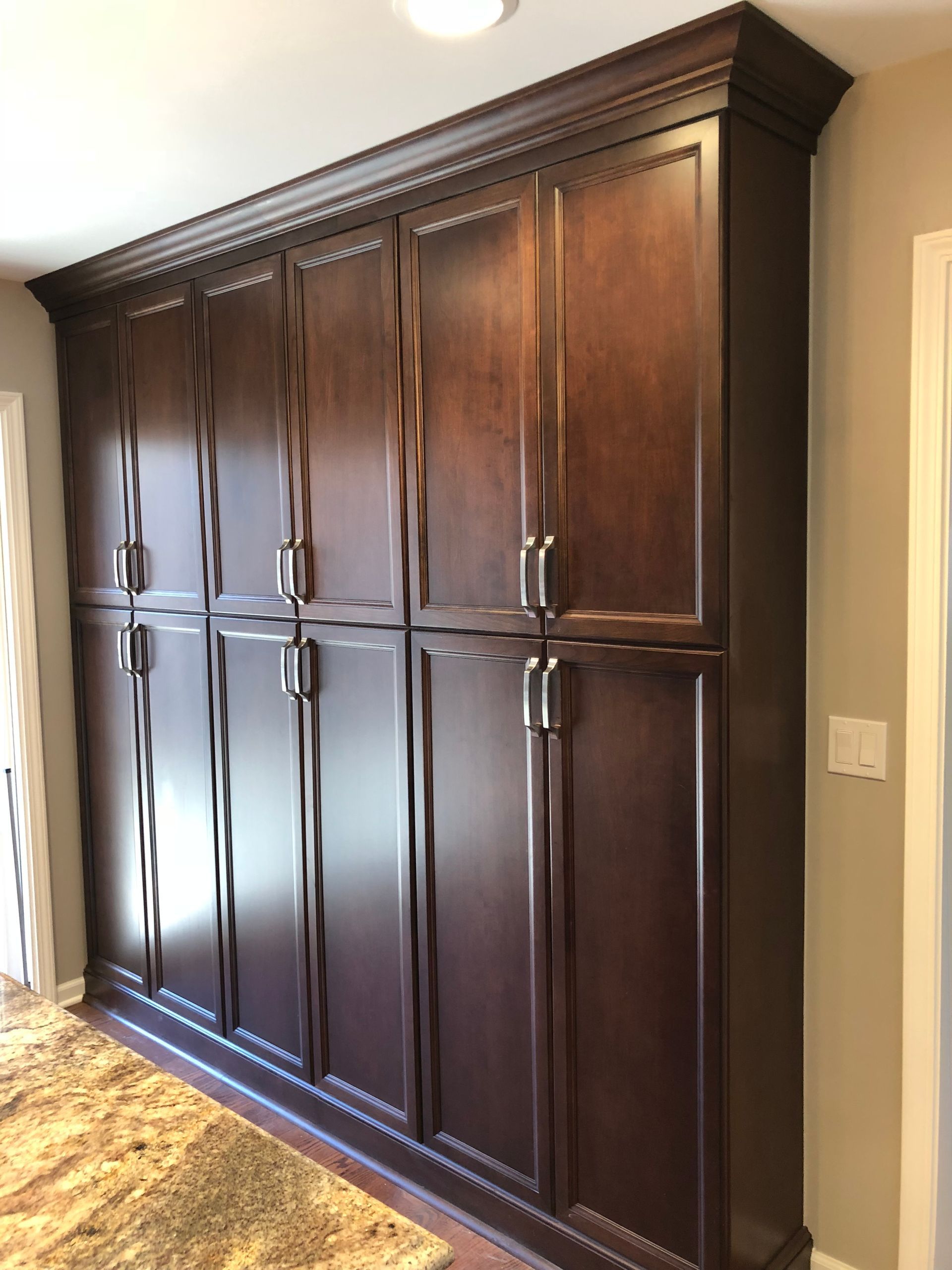 A large wooden cabinet with lots of doors in a room.