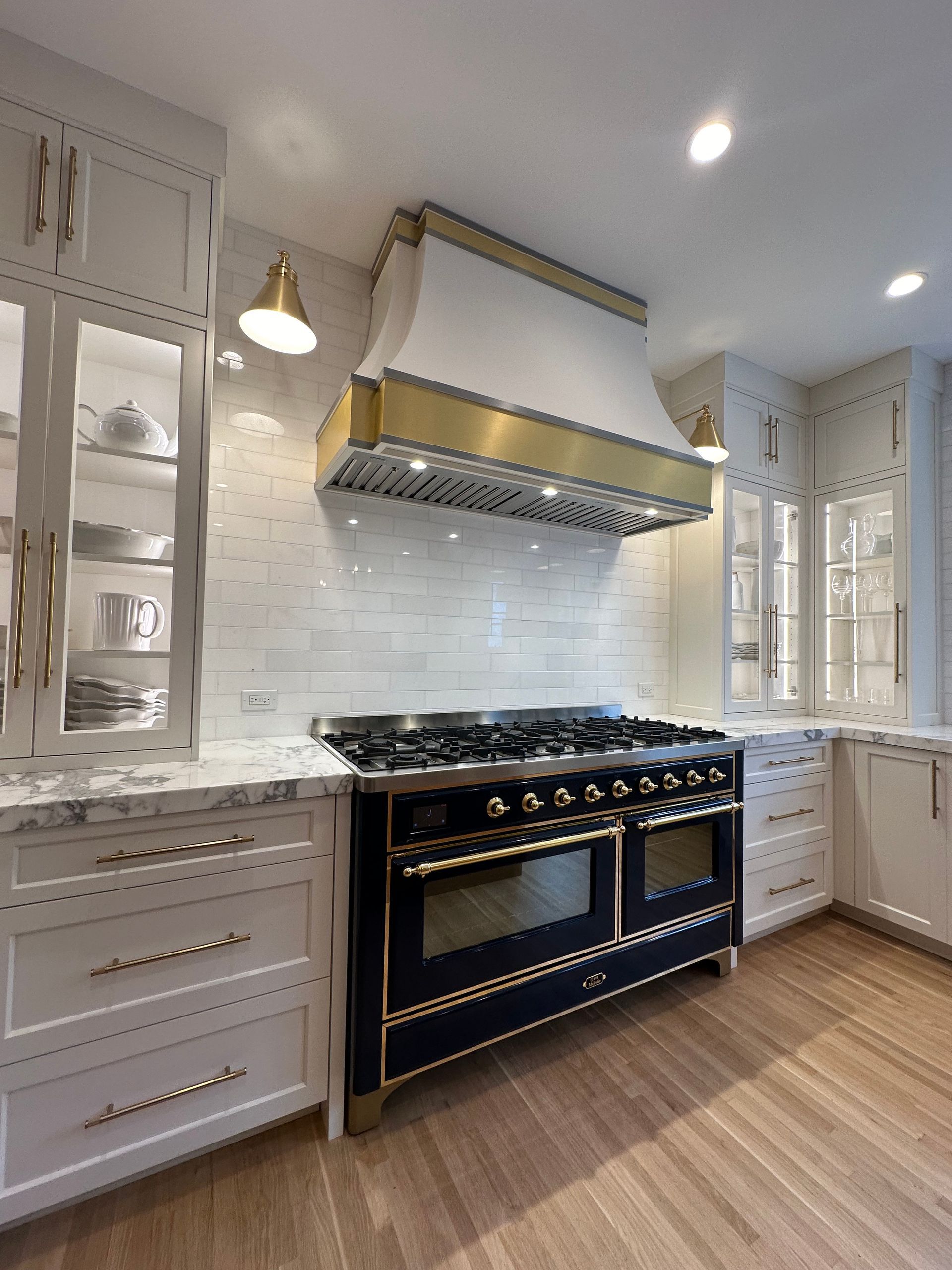 A kitchen with a stove , oven , and hood.