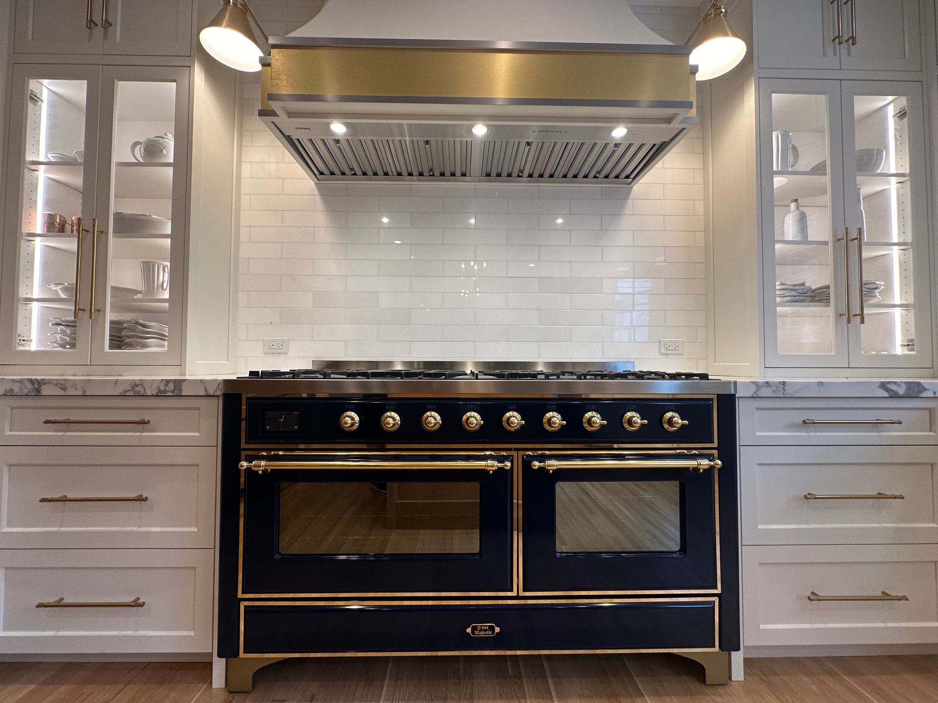 A black and gold stove in a kitchen with white cabinets.