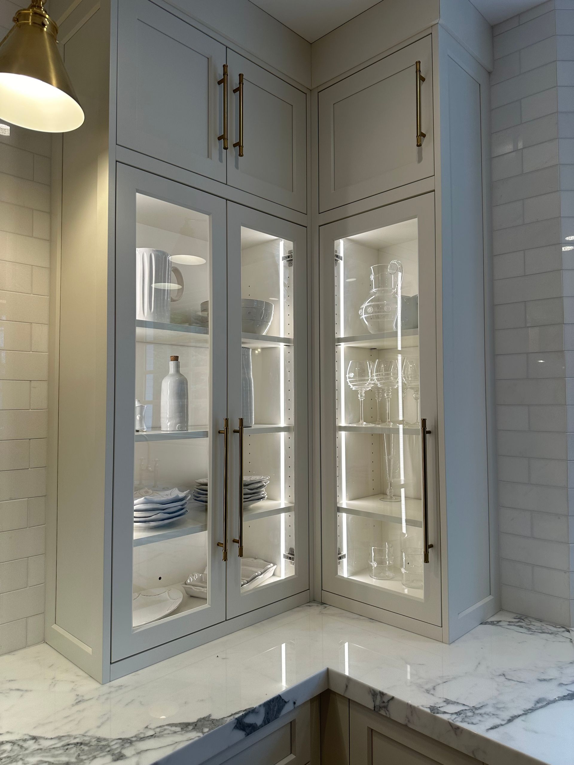 A kitchen with white cabinets and a marble counter top