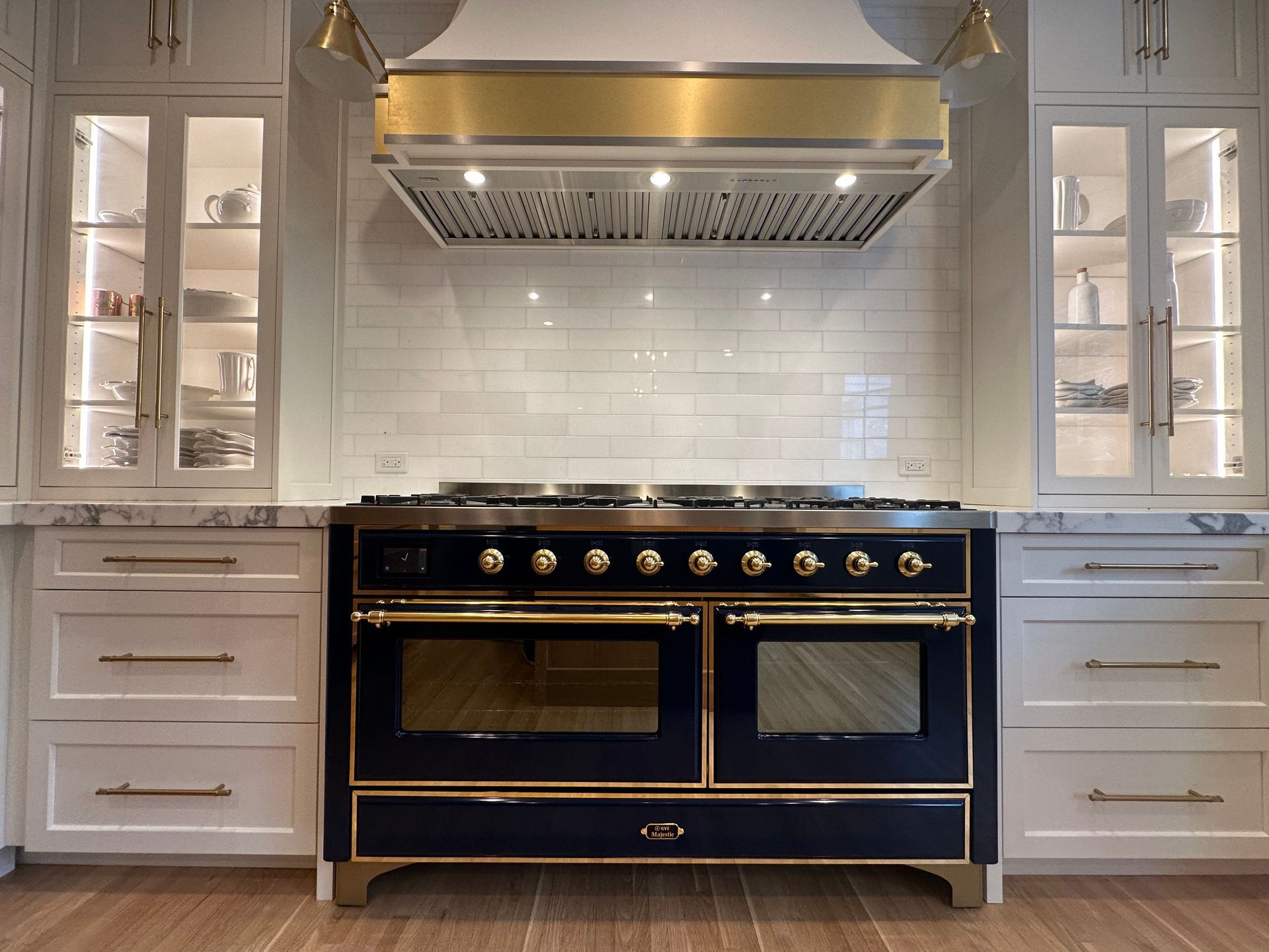 A black and gold stove in a kitchen with white cabinets.