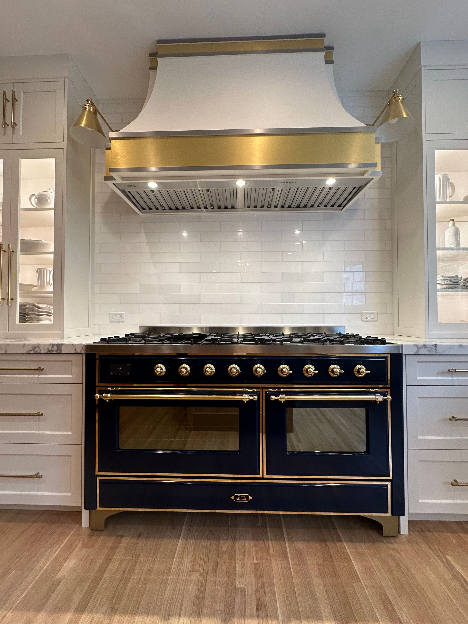 A black and gold stove in a kitchen with white cabinets