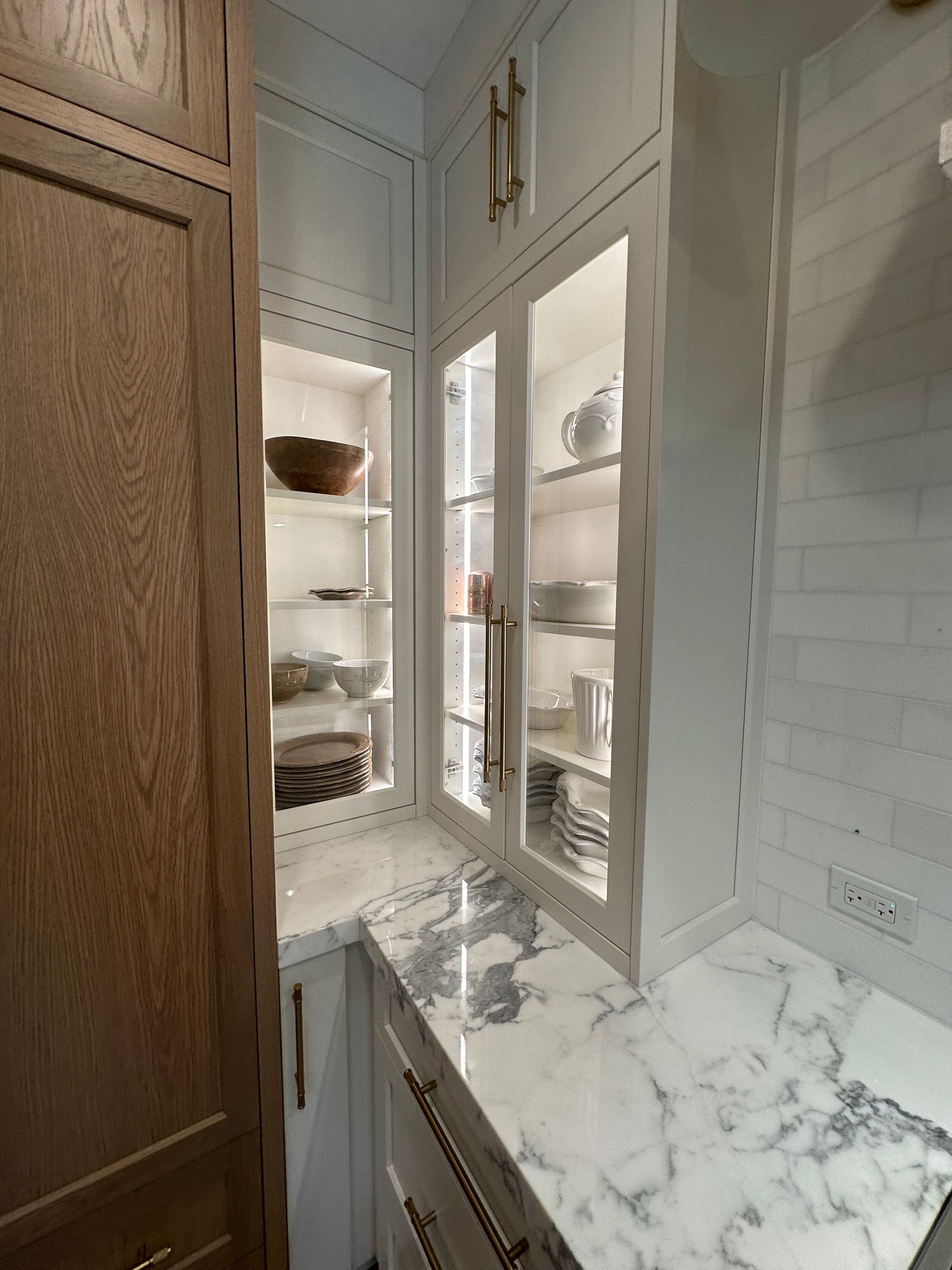 A kitchen with white cabinets and marble counter tops