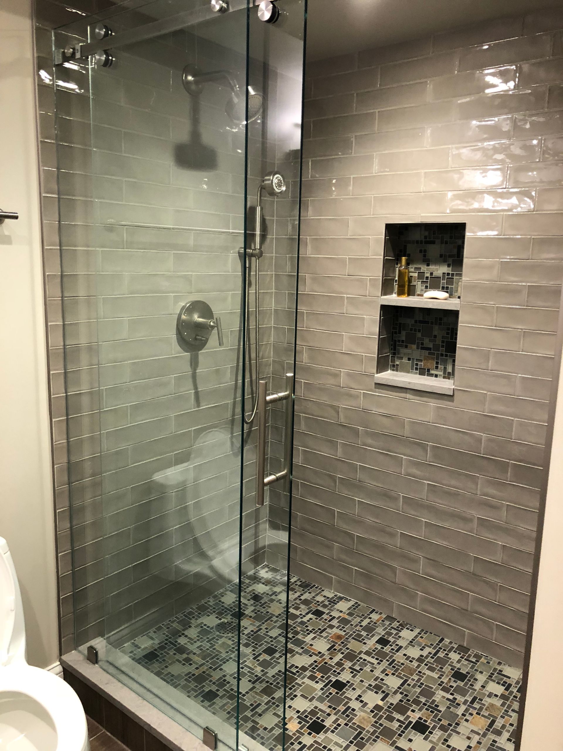 A bathroom with a walk in shower and a toilet.