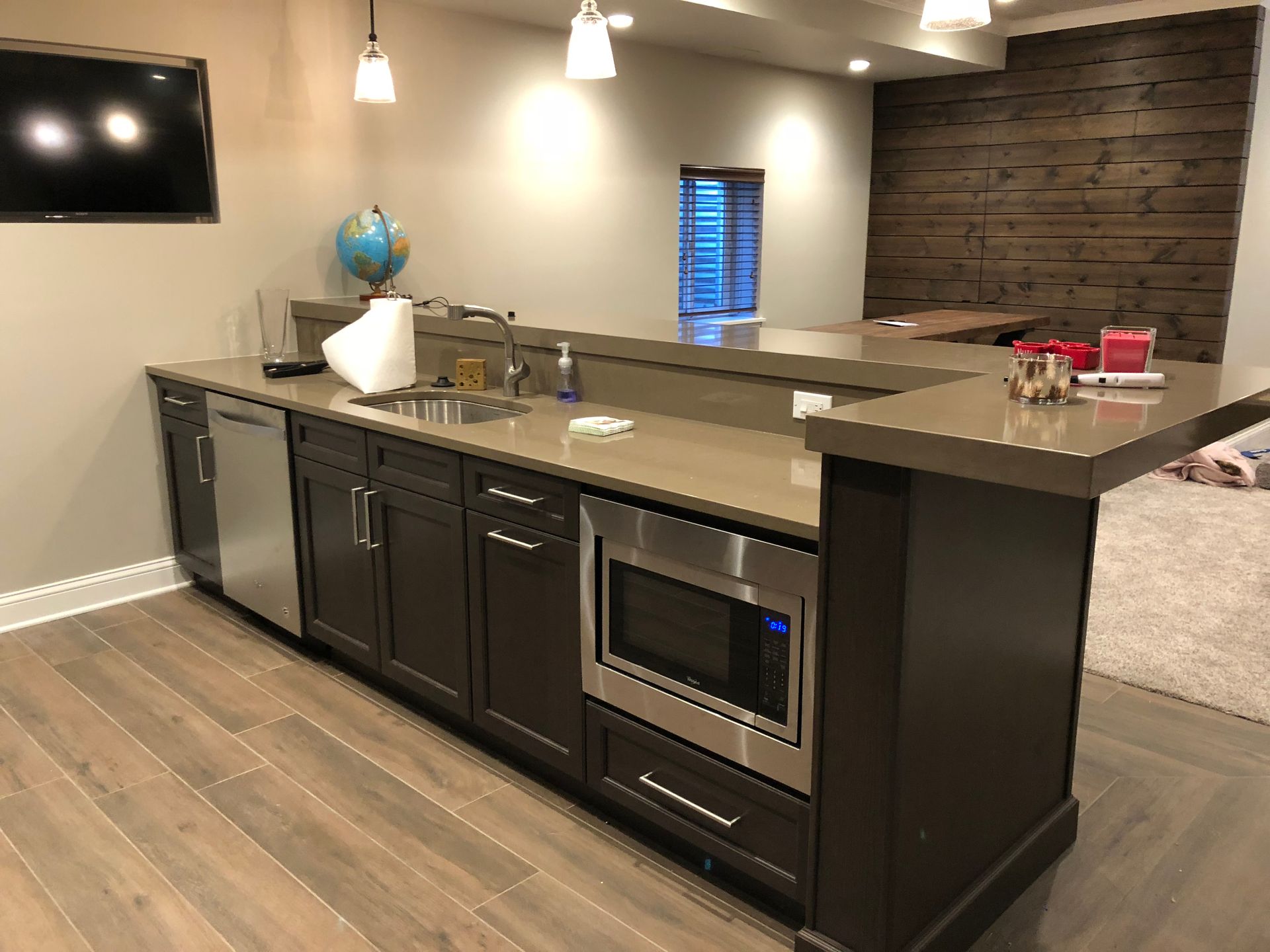 A kitchen with a sink , microwave , and dishwasher.