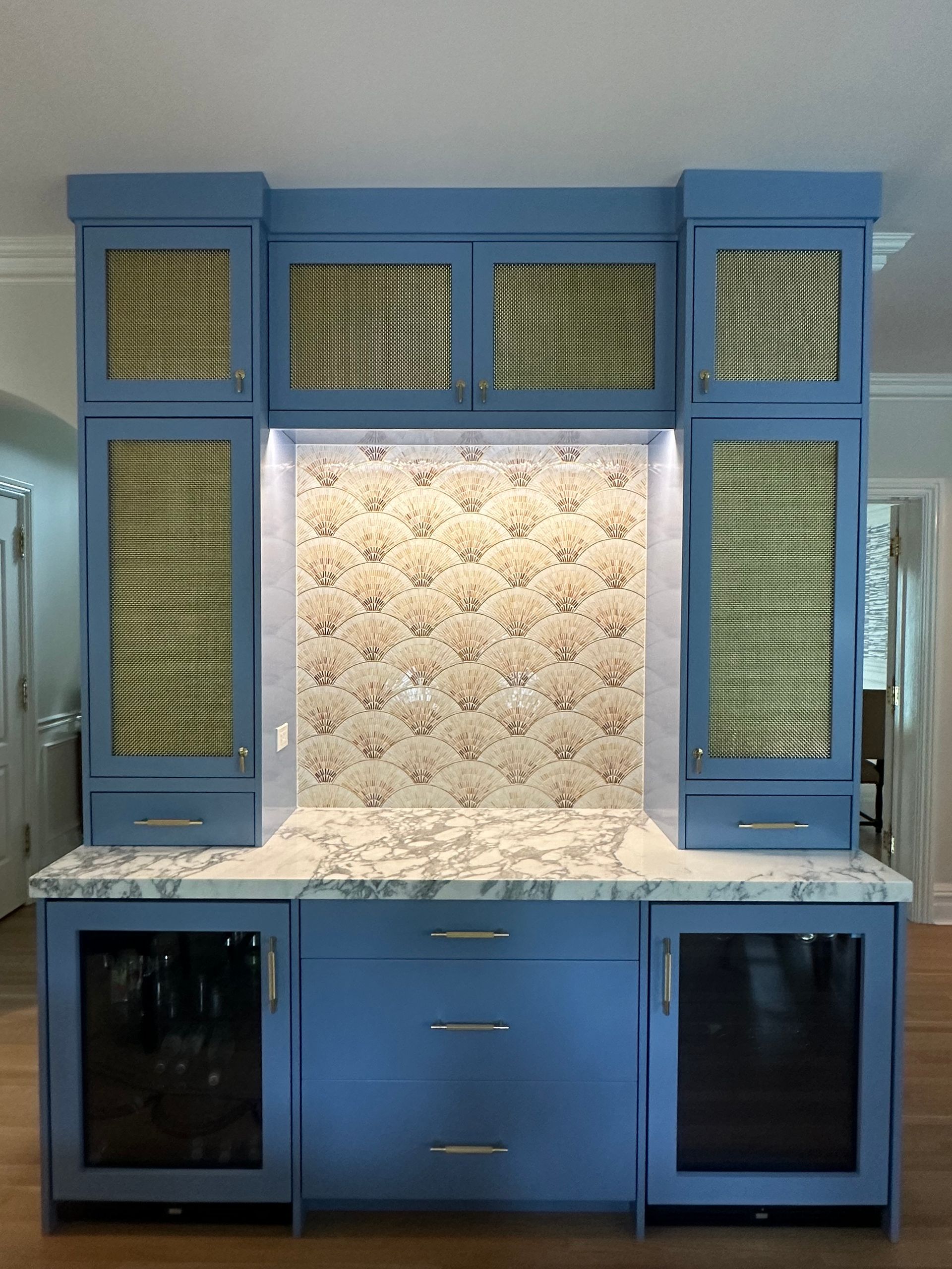 A kitchen with blue cabinets and a marble counter top.