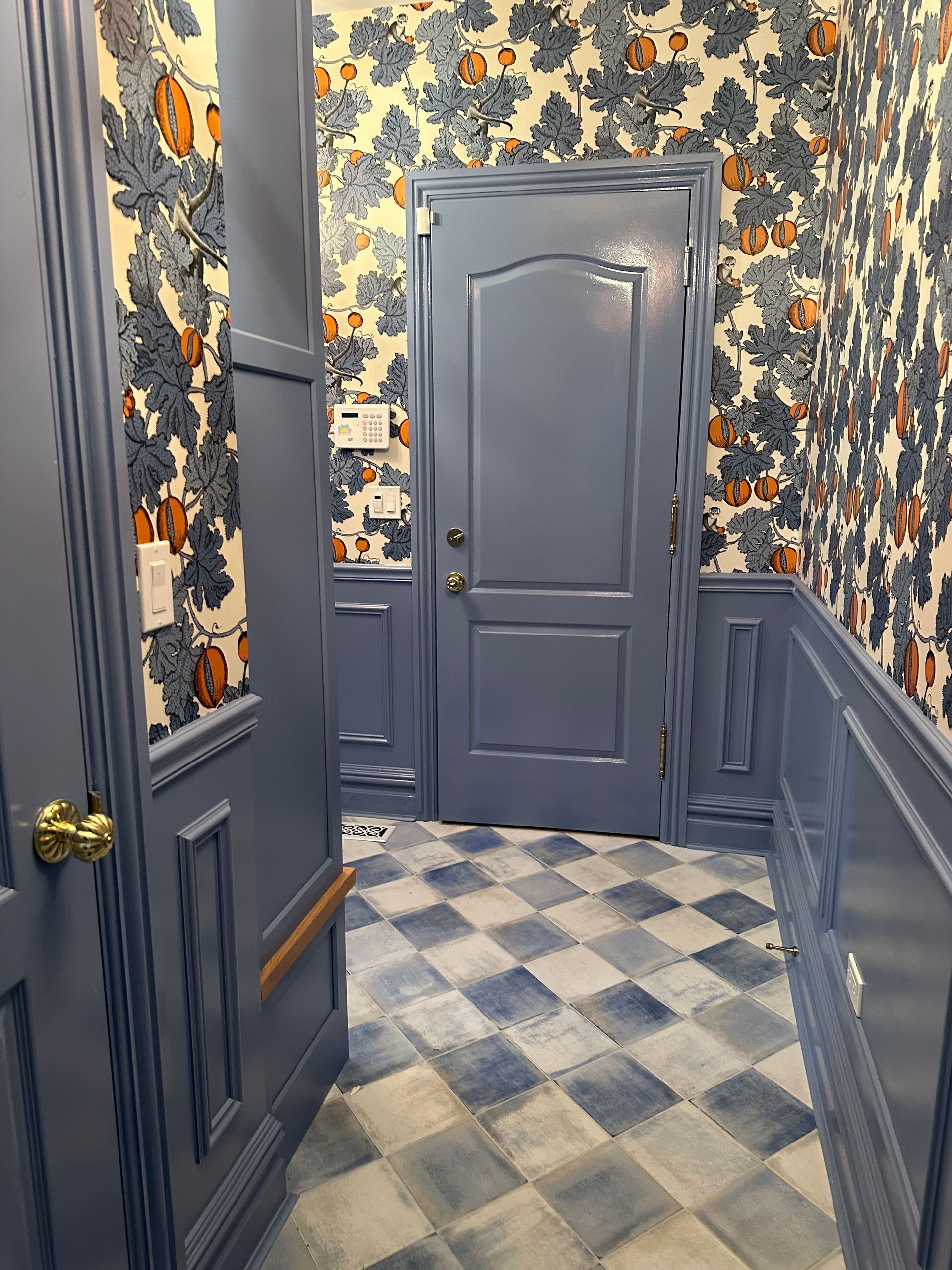 A hallway with blue doors and a checkered floor