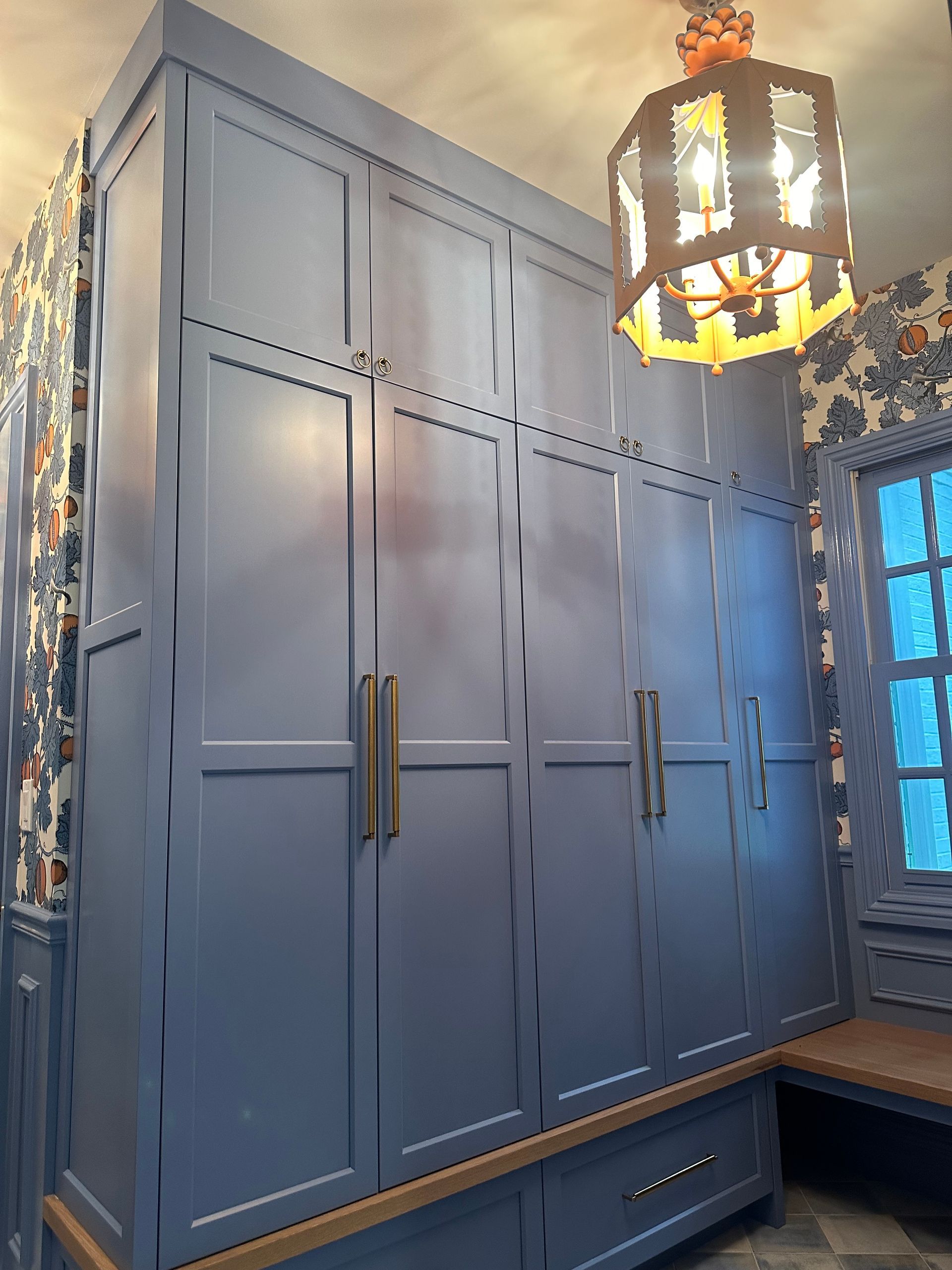 A room with a lot of cabinets and a chandelier hanging from the ceiling.