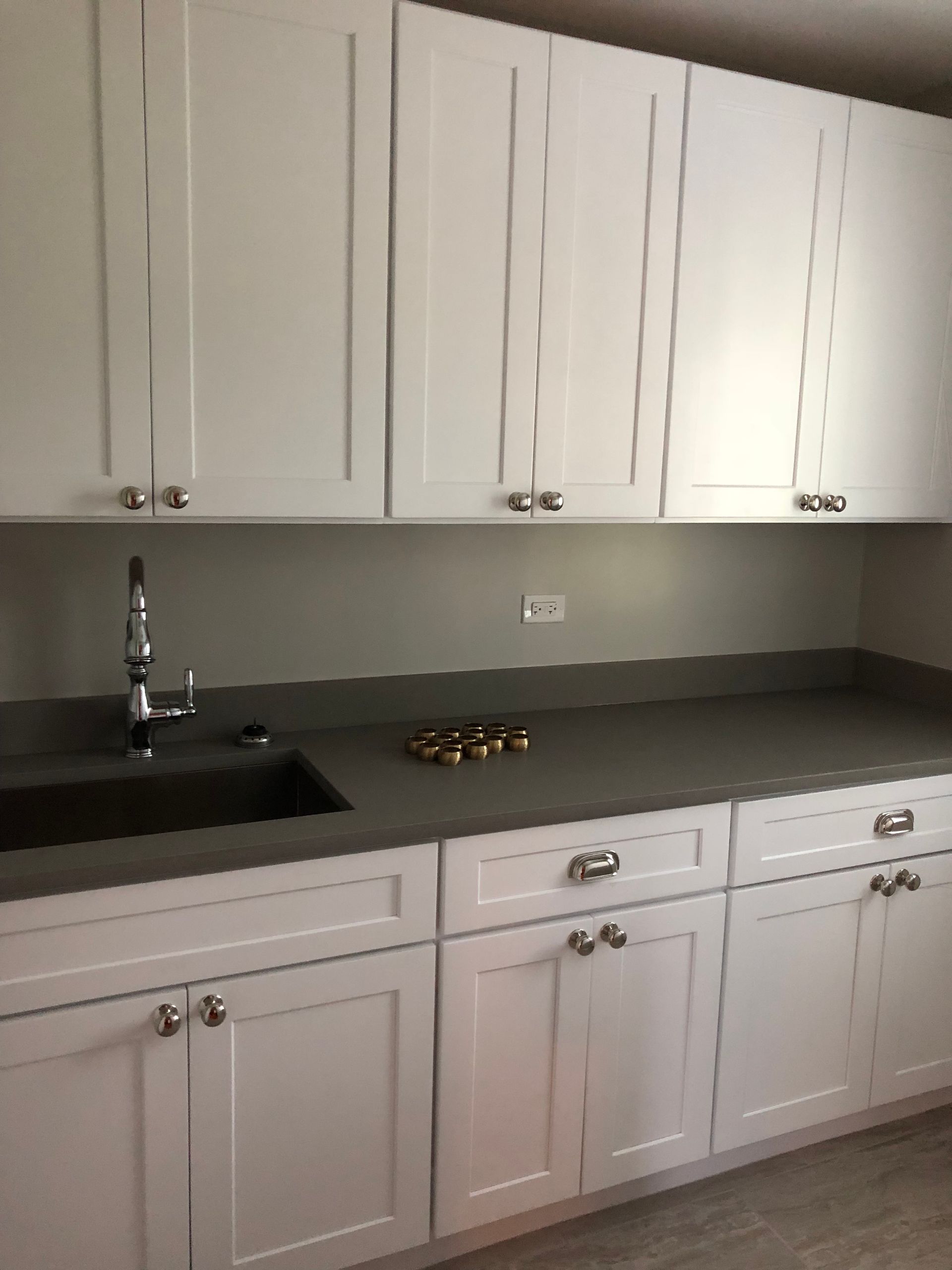 A kitchen with white cabinets and a sink