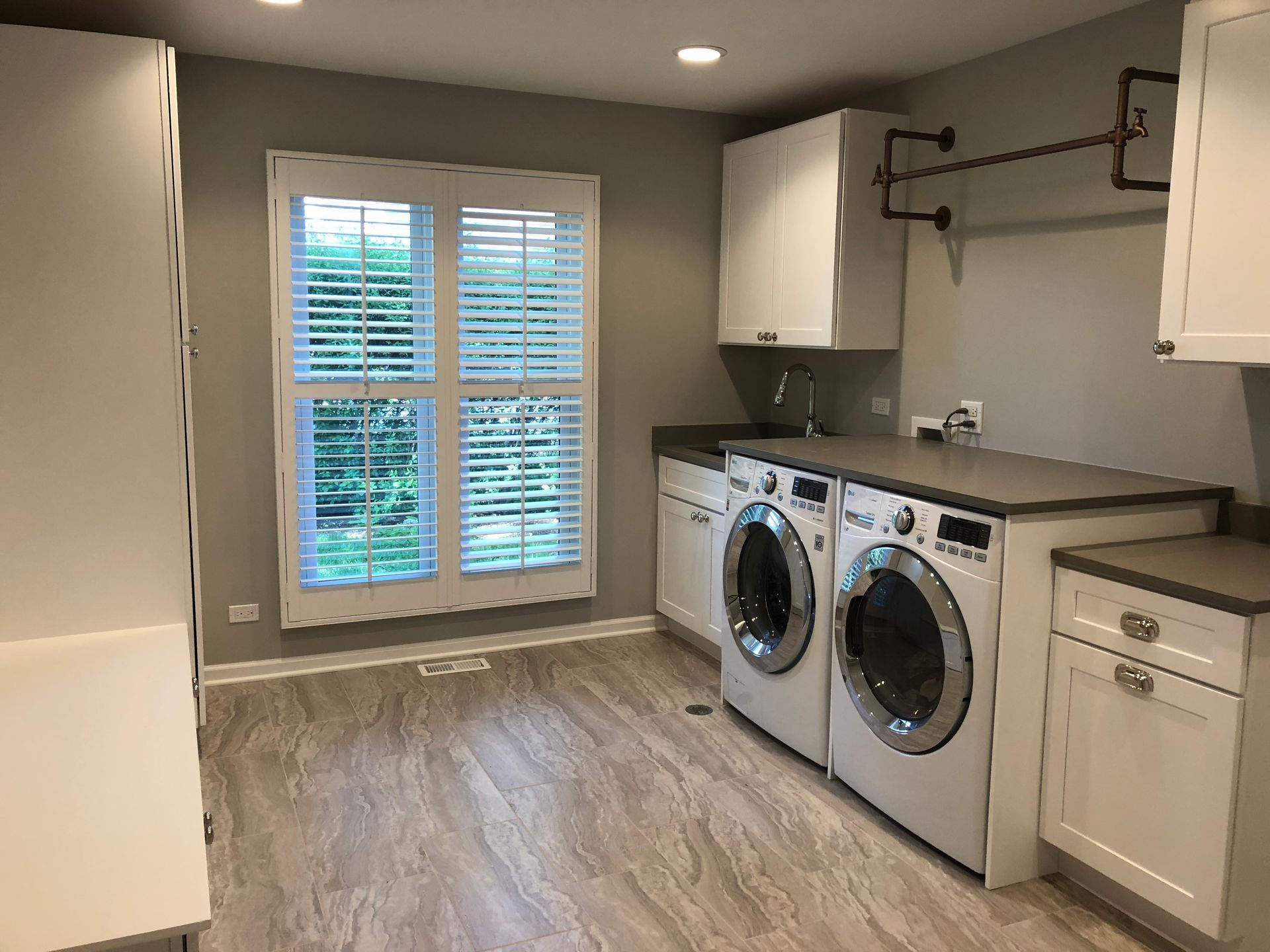 A laundry room with a washer and dryer and a window.