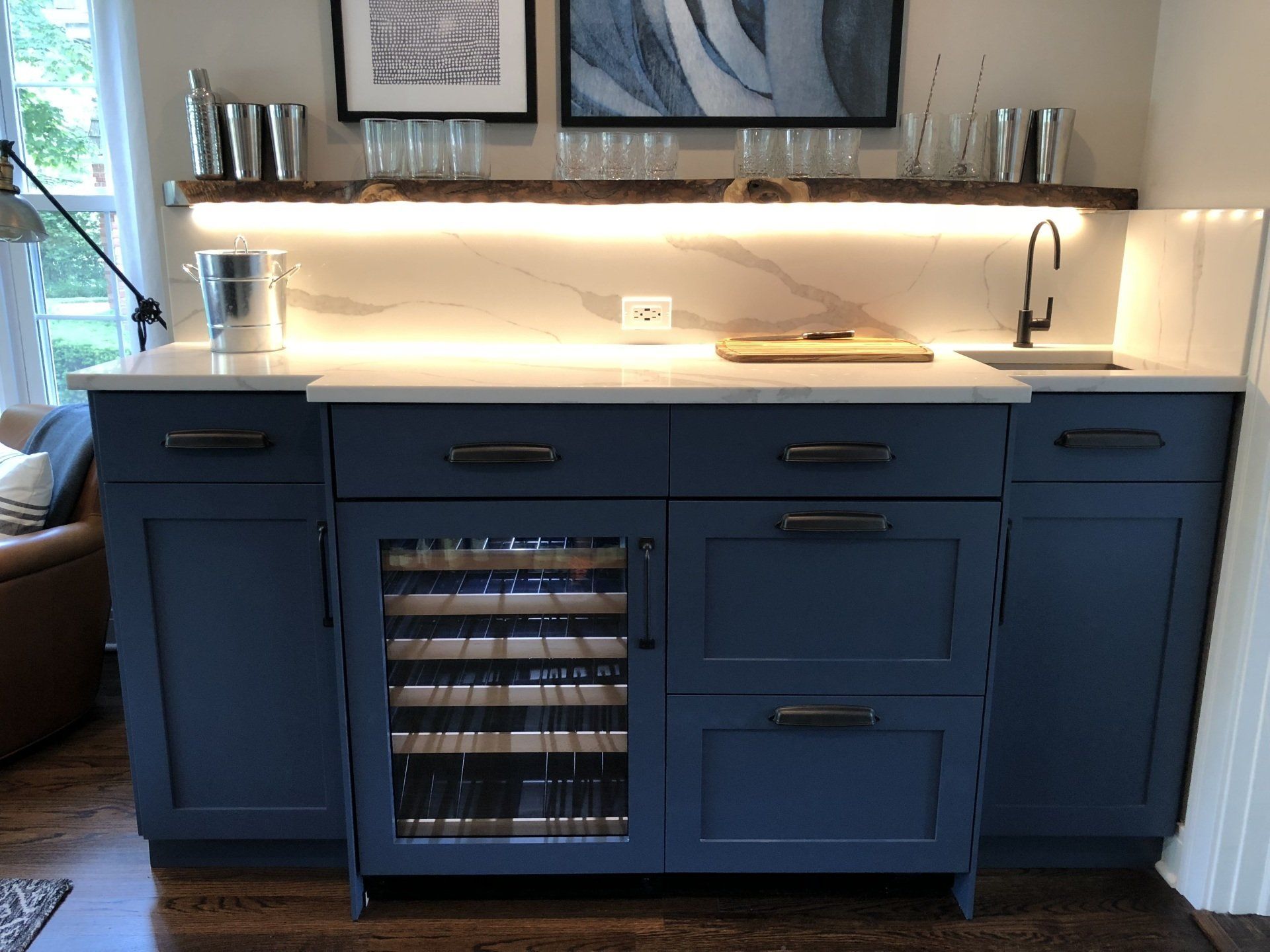 A kitchen with blue cabinets and a wine cooler.