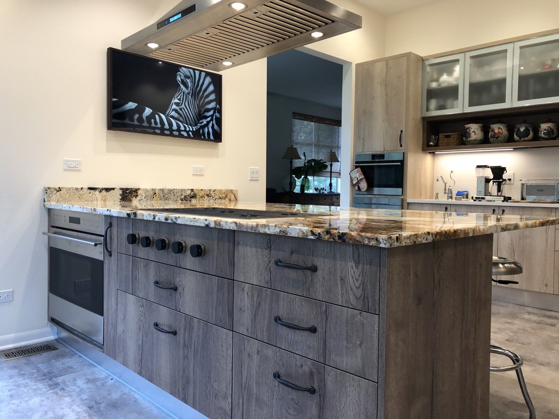 A kitchen with a large island and a picture of a zebra on the wall.