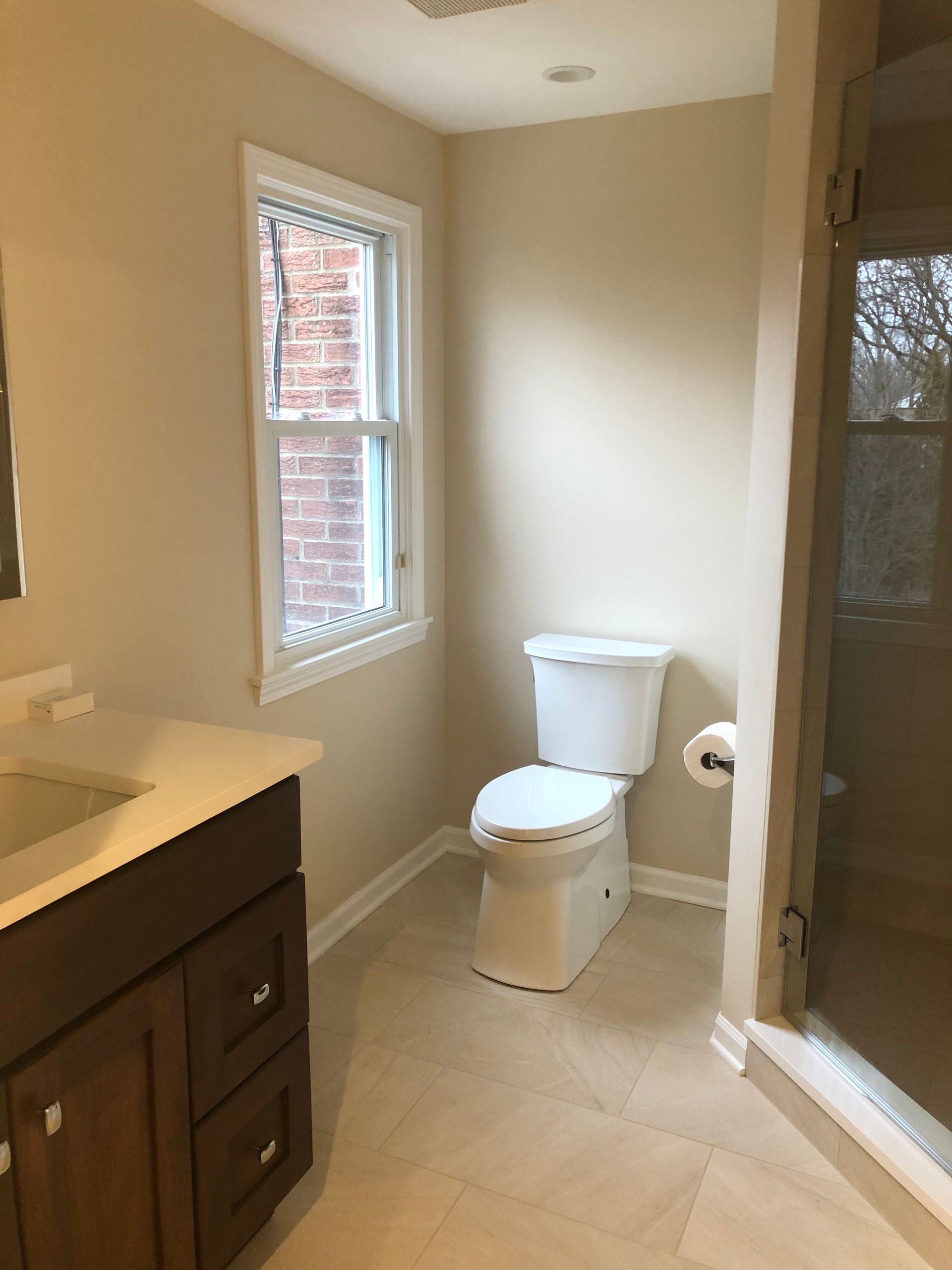 A bathroom with a toilet a sink and a window