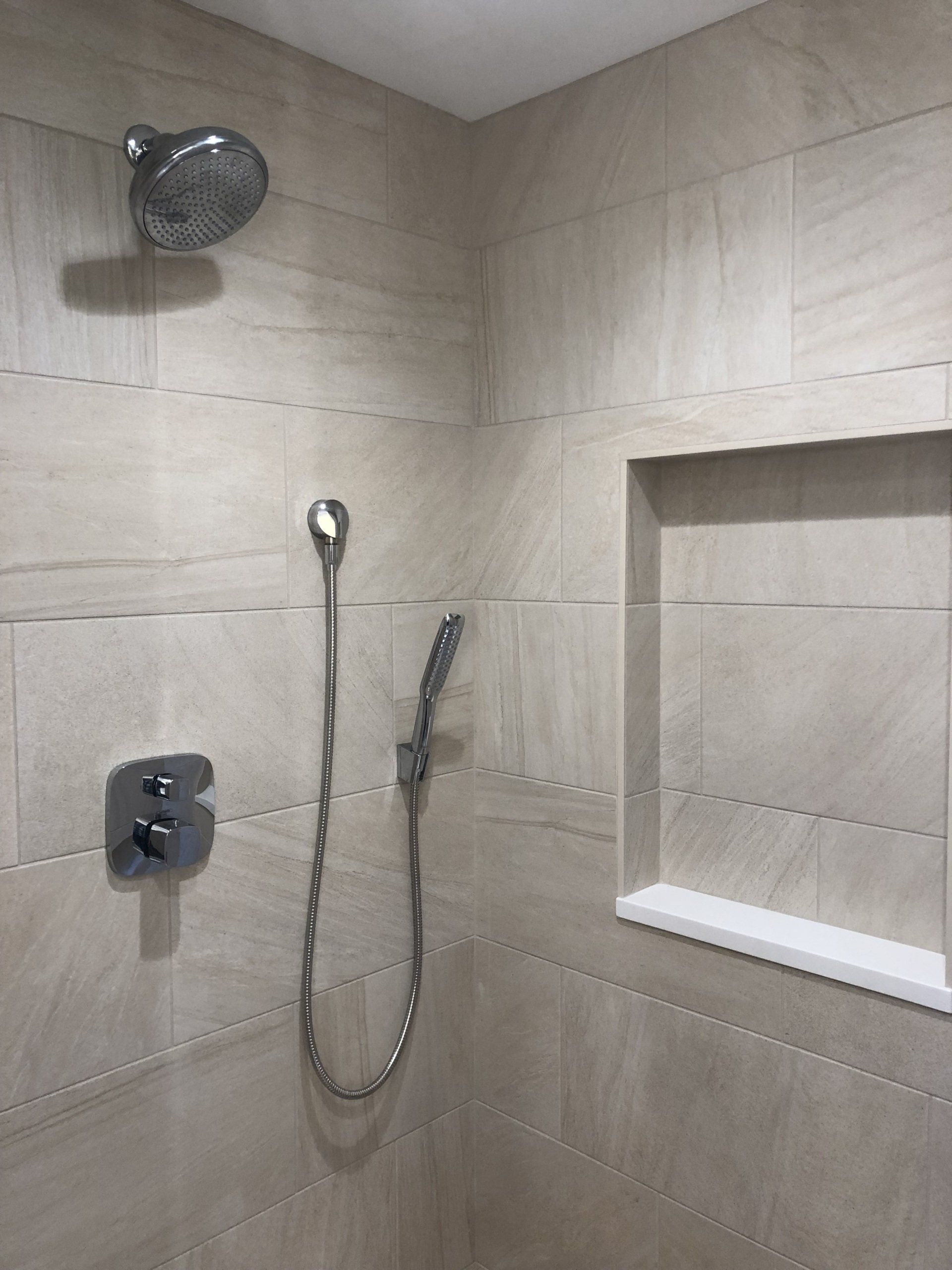 There is a shower head and a shower head in the shower.