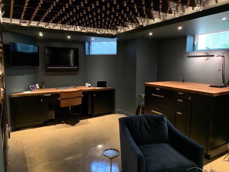 A room with a desk , chair , television and a chair.