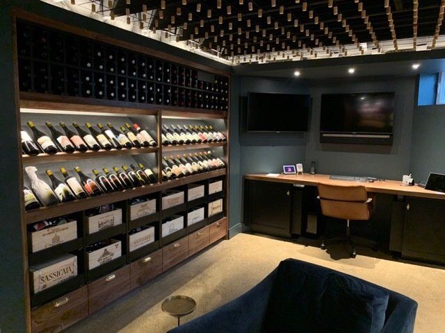 There are many bottles of wine on the shelves in this room.