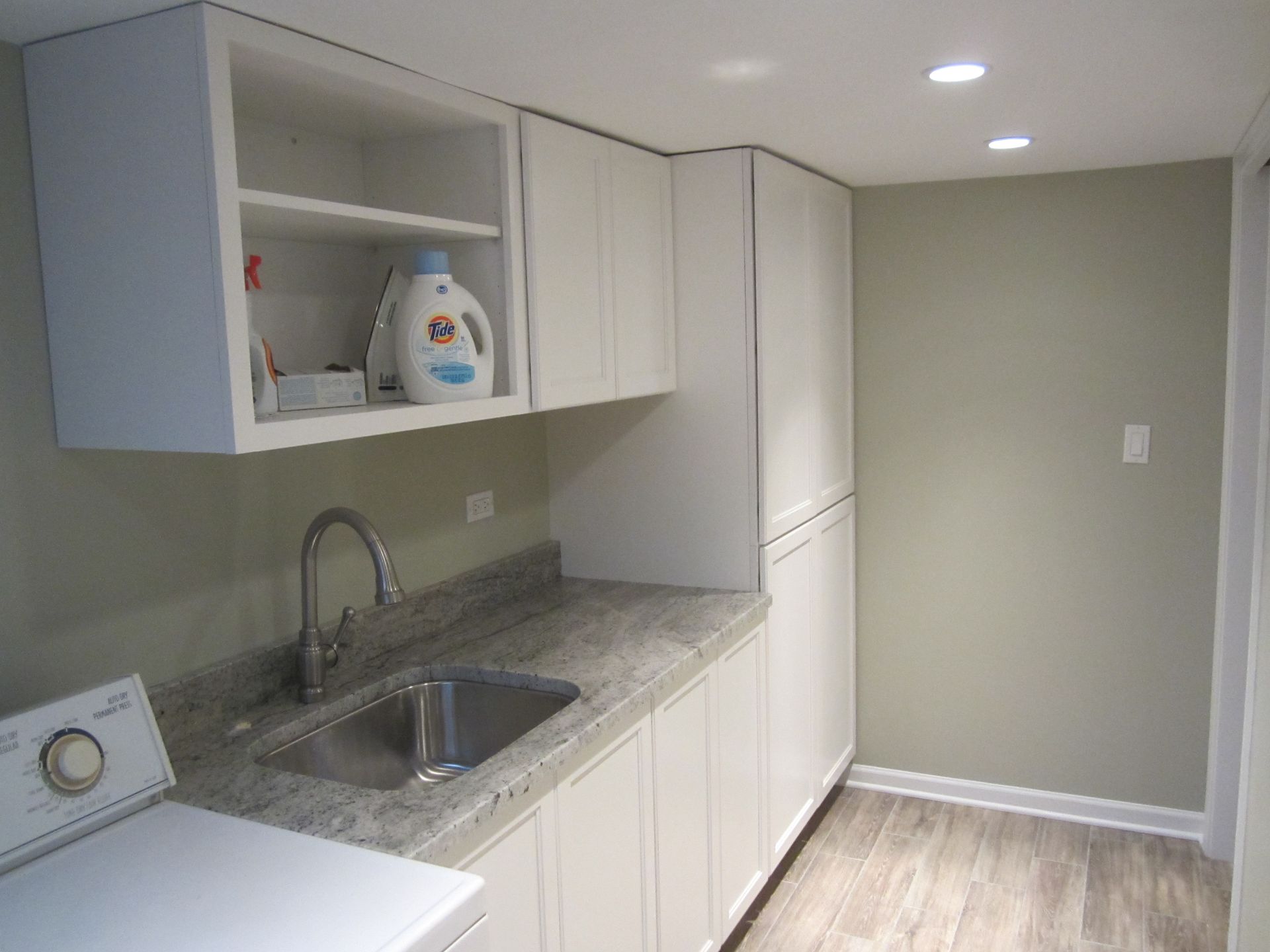 A laundry room with a washer and dryer and a sink.