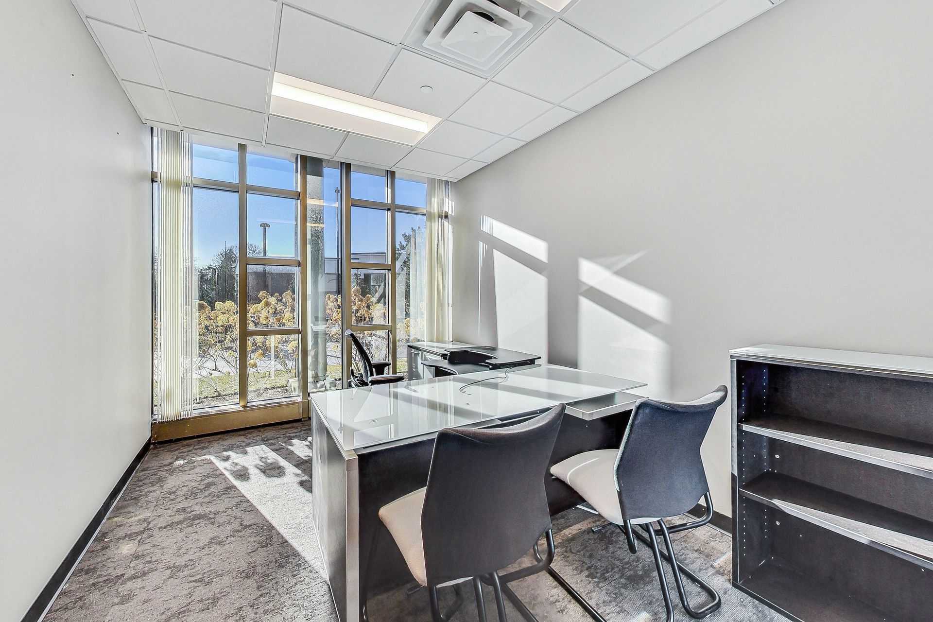 A small office with a desk and chairs in it.