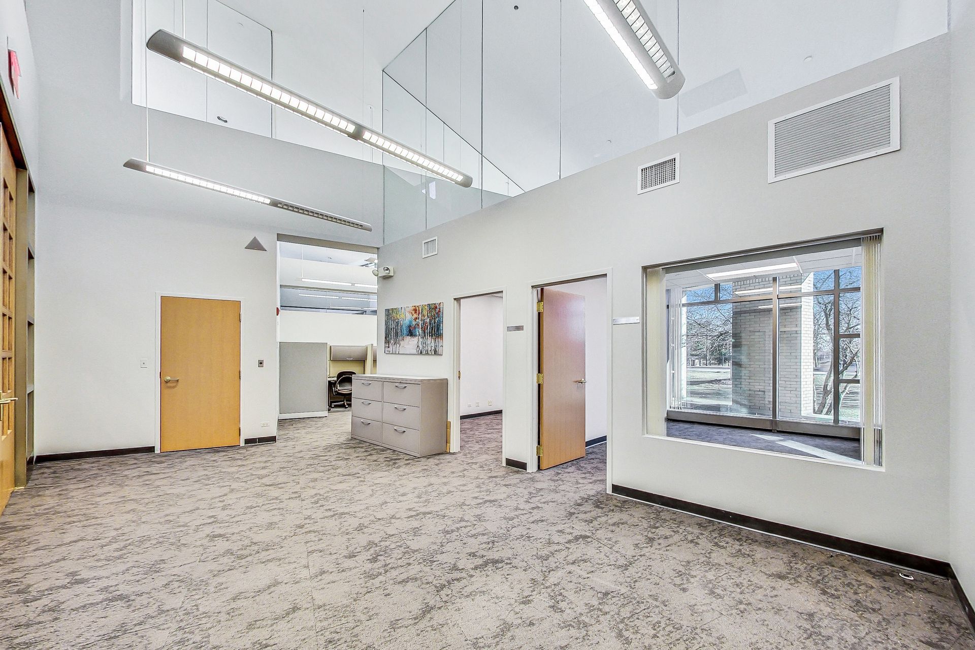 A large empty room with a lot of windows and doors.