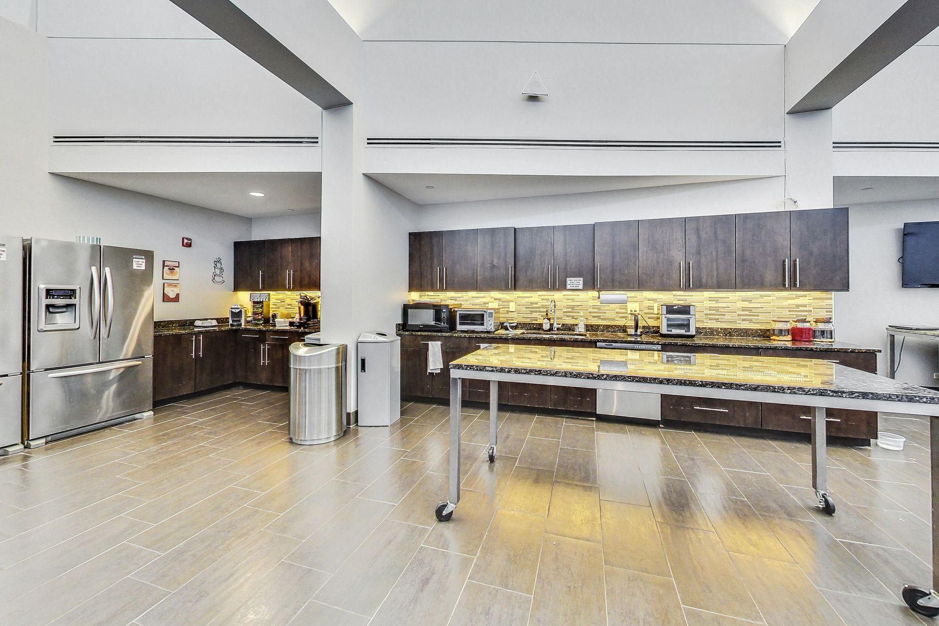 A large kitchen with stainless steel appliances and a table.
