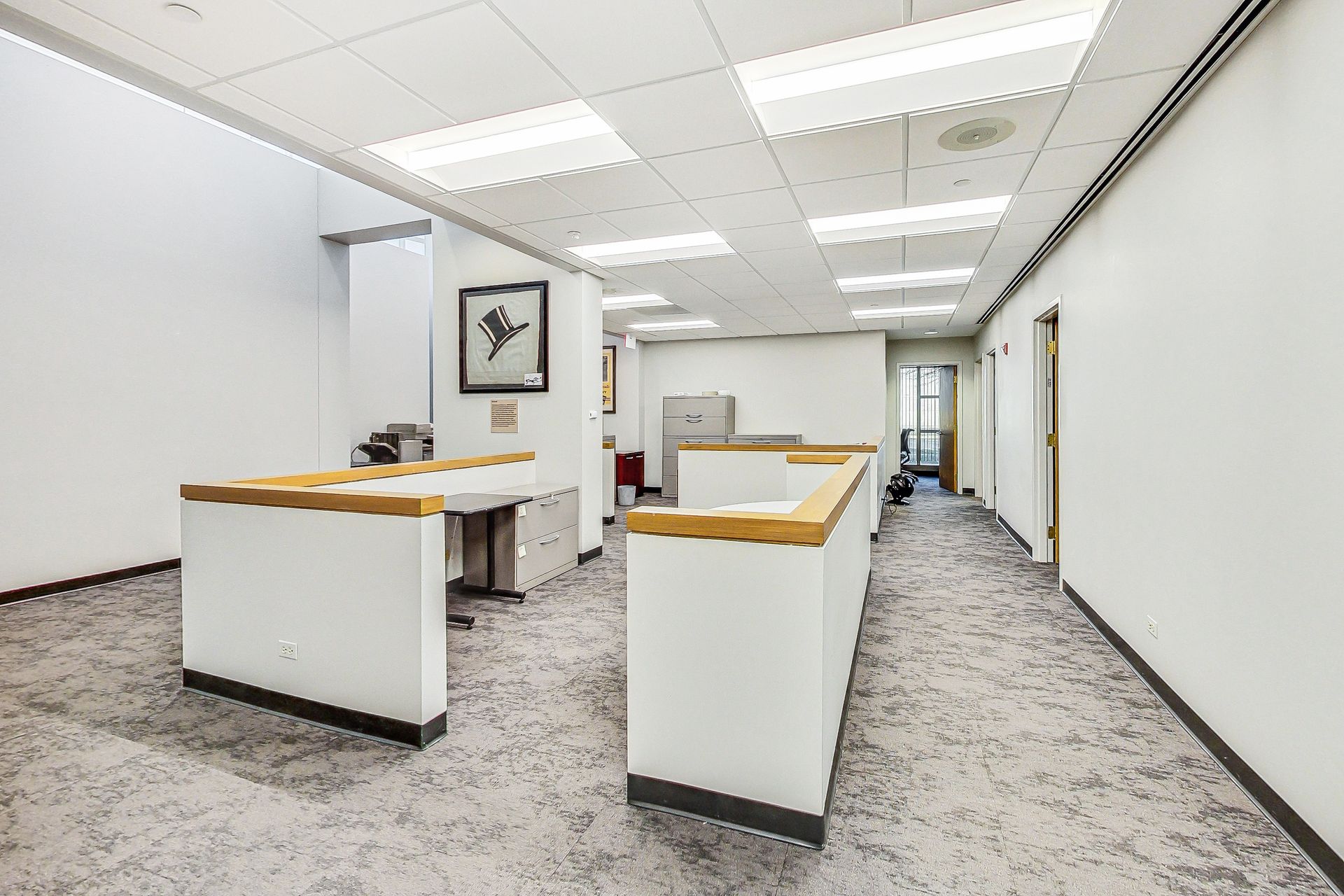 A long hallway with a lot of white walls and a carpeted floor.