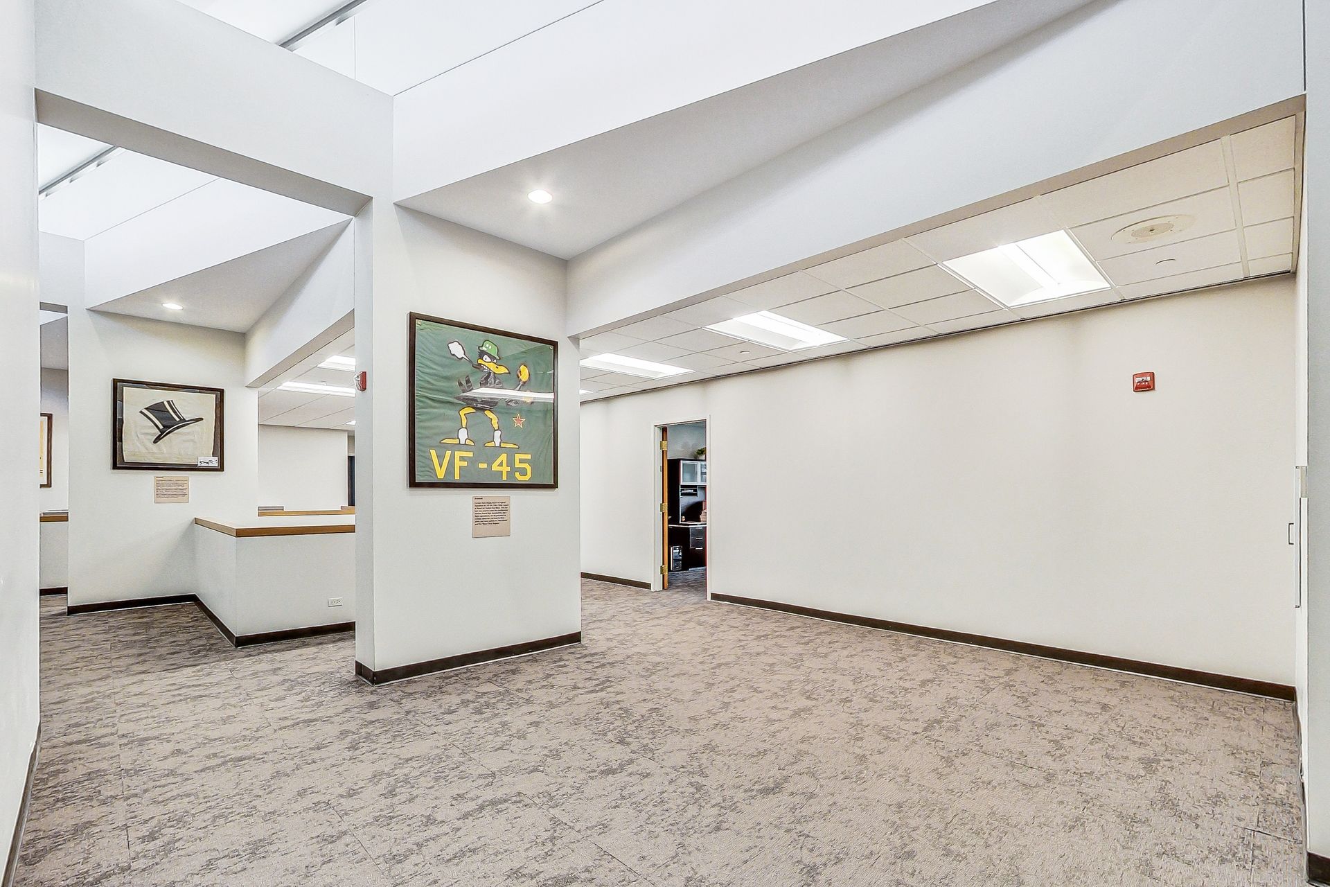 A large empty room with a scoreboard on the wall.