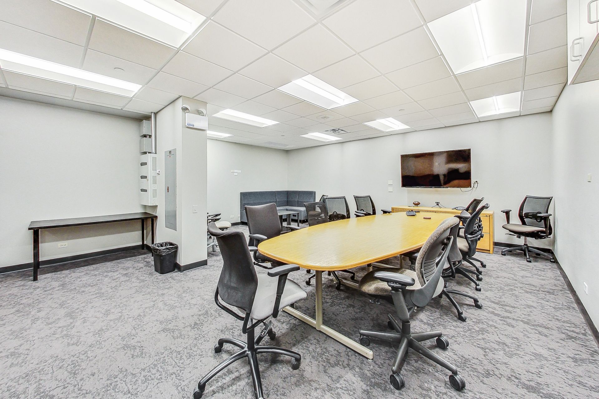 A conference room with a long table and chairs.