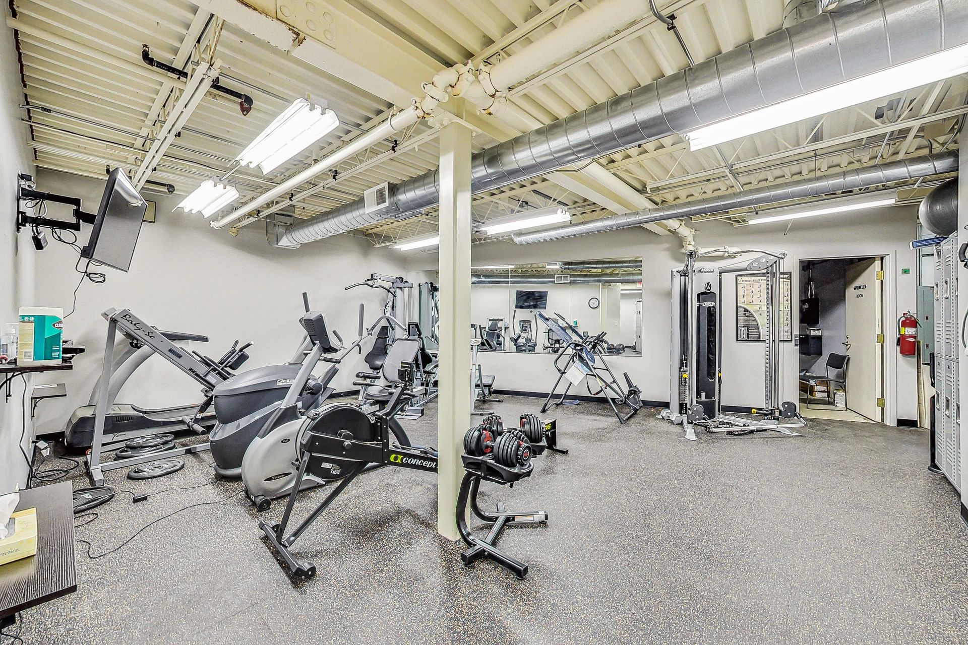 A large gym filled with lots of exercise equipment.