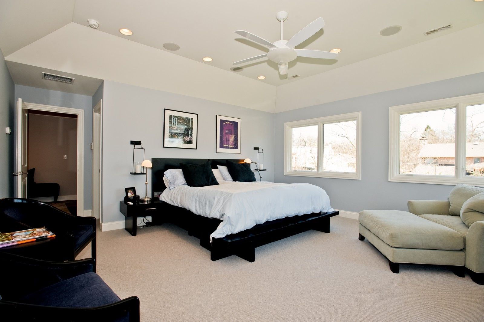 A bedroom with a large bed and a ceiling fan