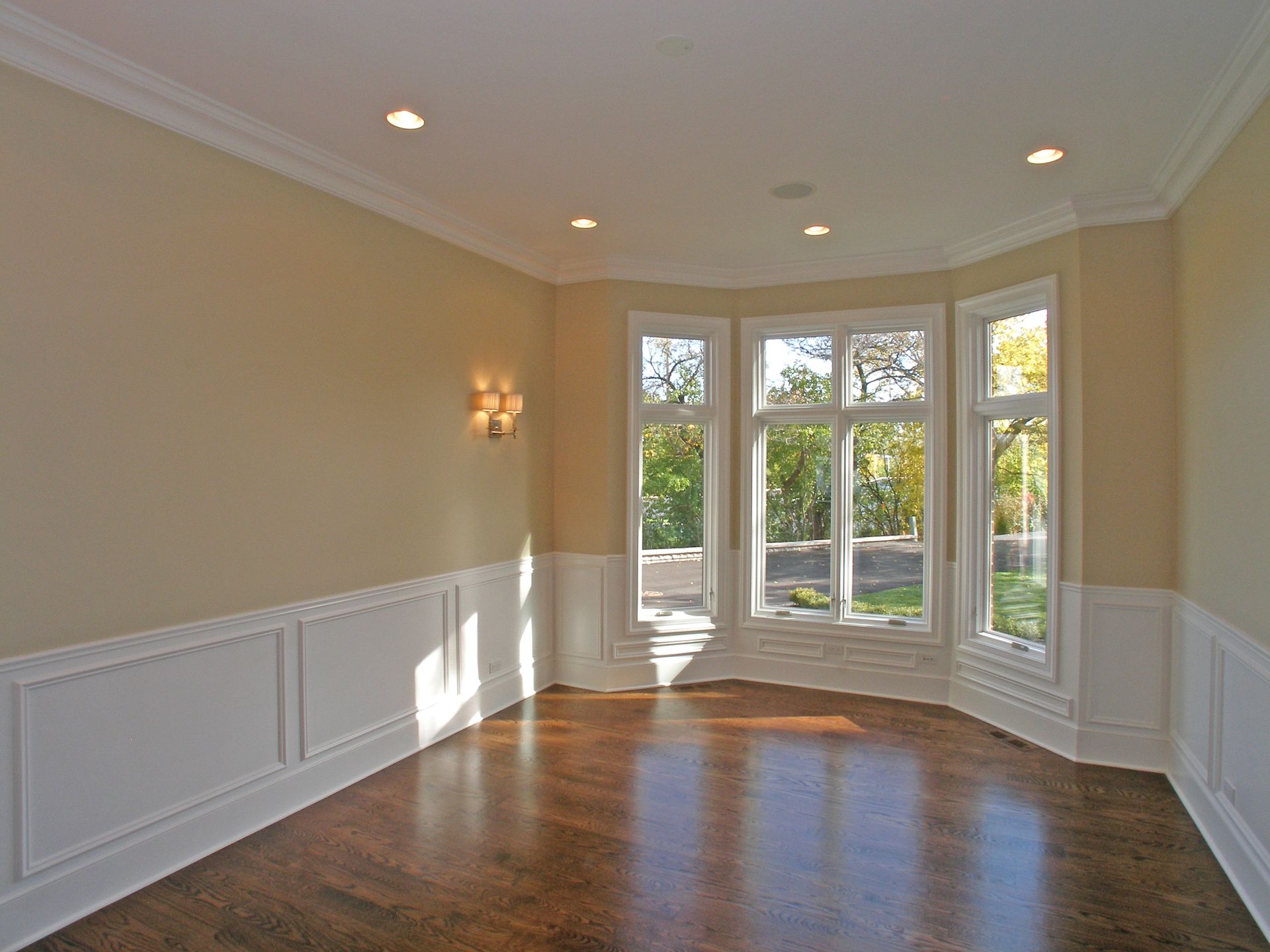 An empty room with hardwood floors and lots of windows