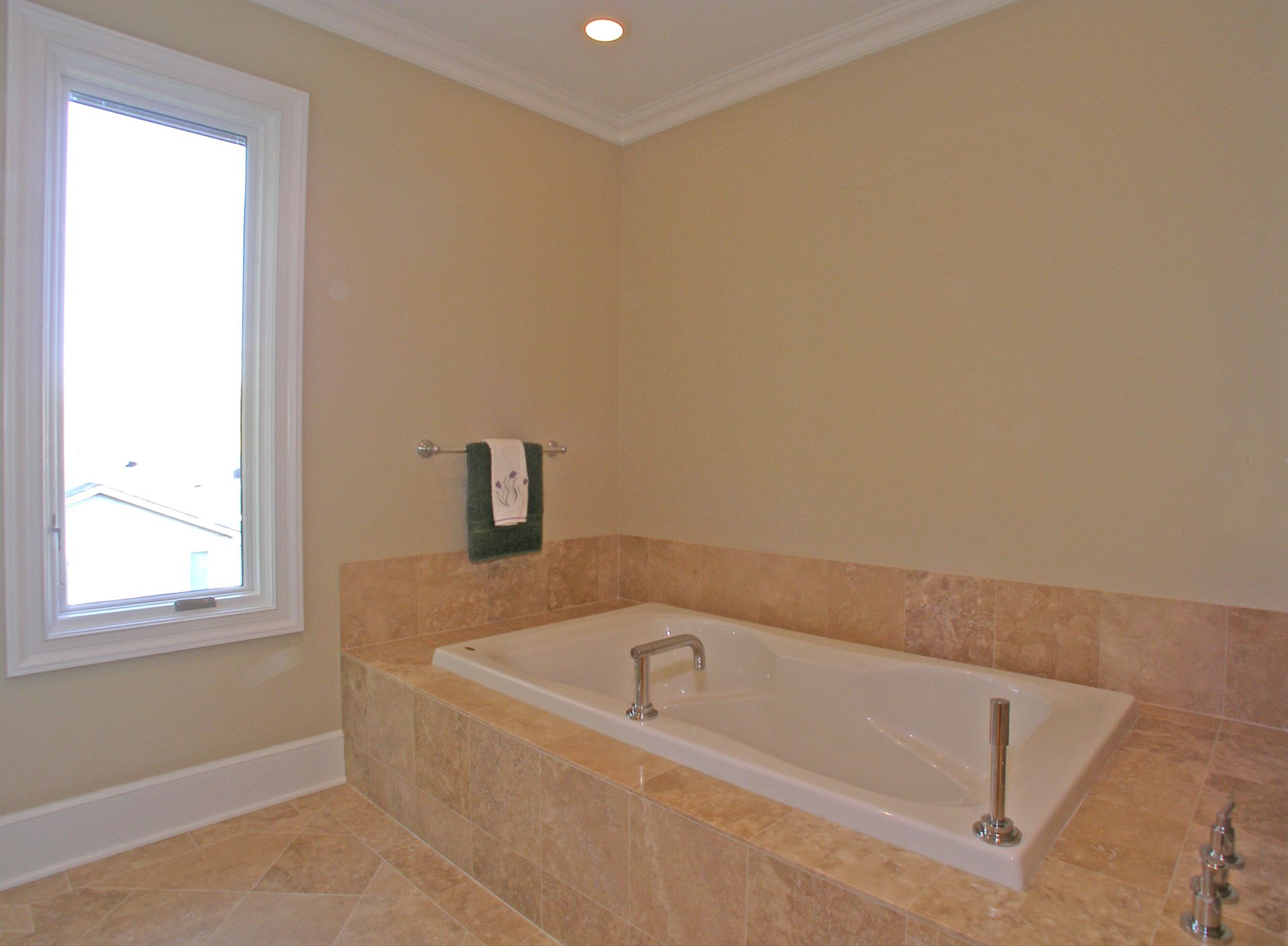 A bathroom with a large tub and a window.