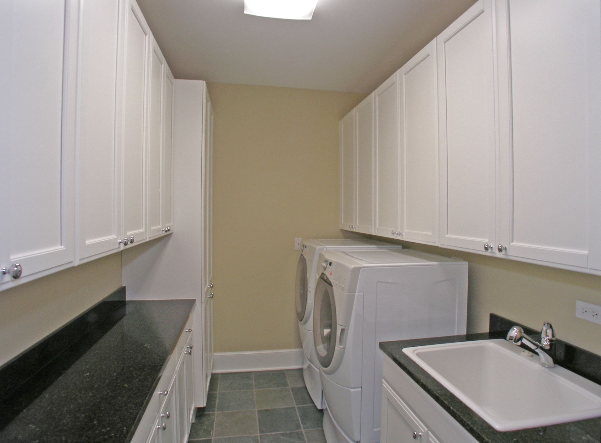 A laundry room with a washer and dryer and a sink