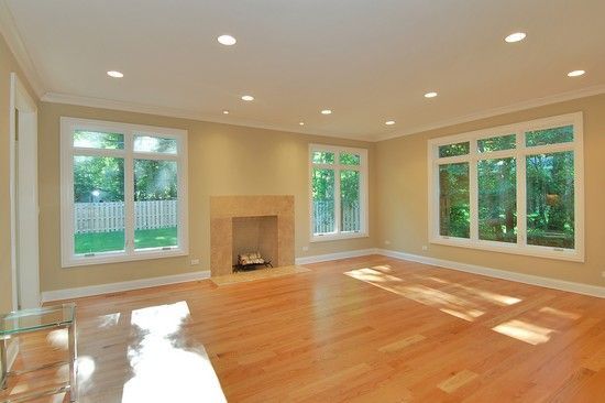 An empty living room with hardwood floors and a fireplace.