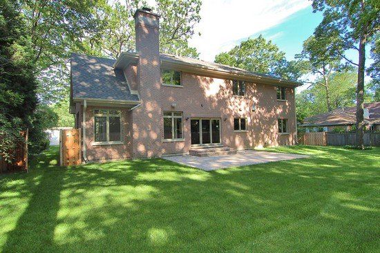 A large brick house with a large lawn in front of it