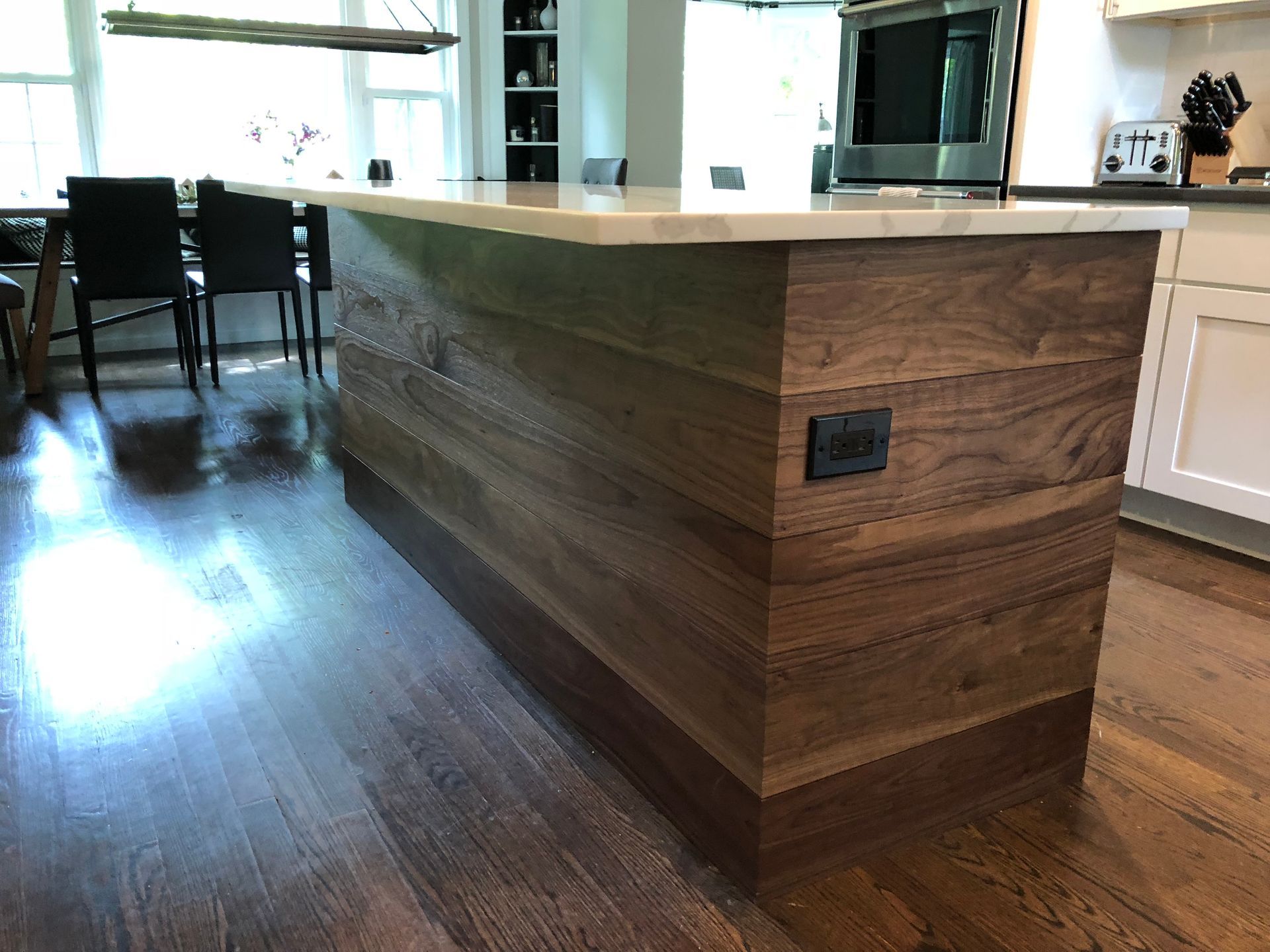 A kitchen with a large wooden island in the middle