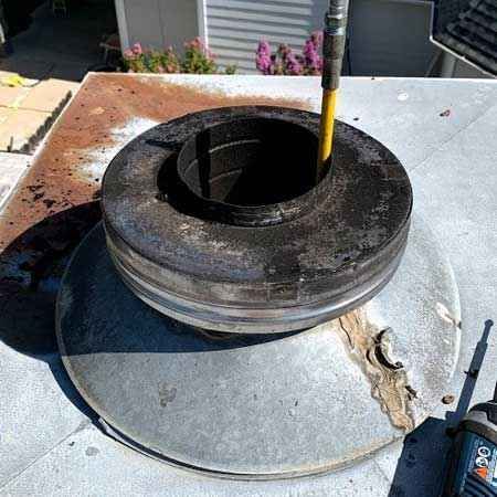 A large metal object is sitting on top of a roof.
