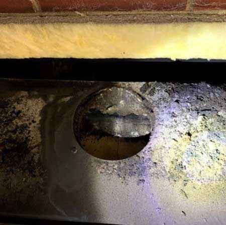 A close up of a hole in a brick wall.