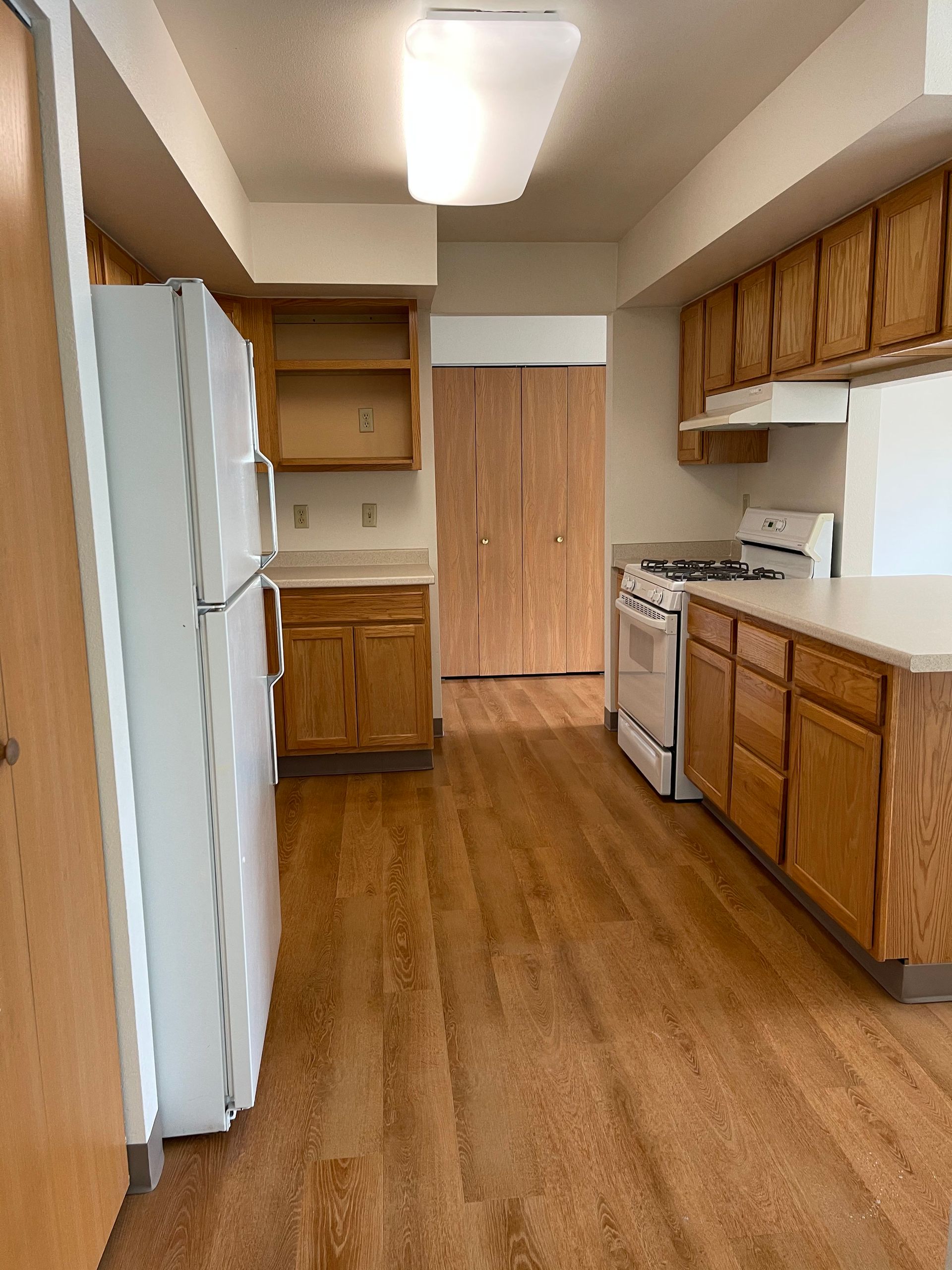 A kitchen with wooden cabinets and a white refrigerator