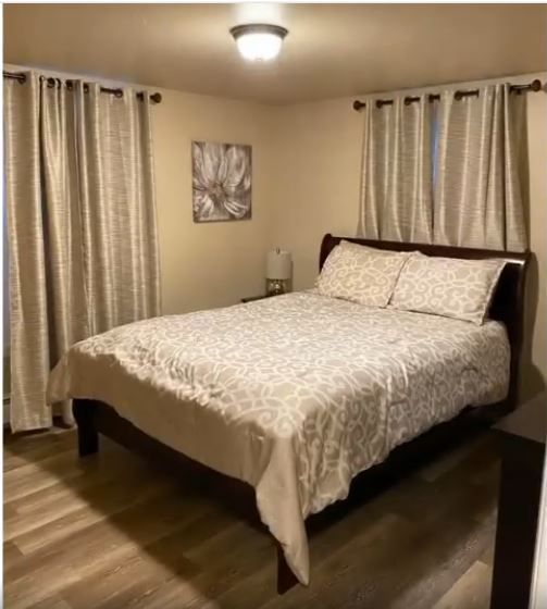 A bedroom with a king size bed and curtains