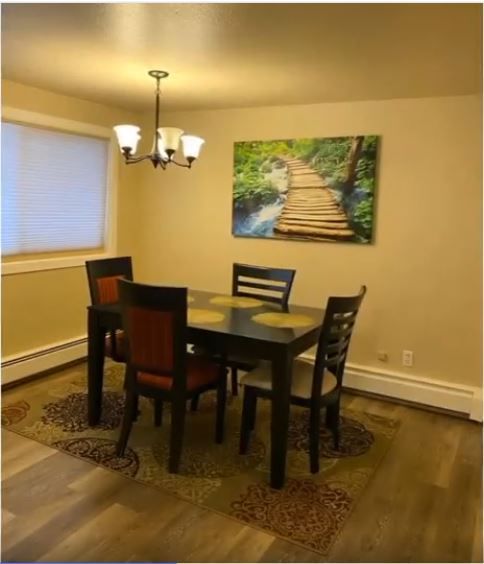 A dining room with a table and chairs and a picture of a bridge on the wall